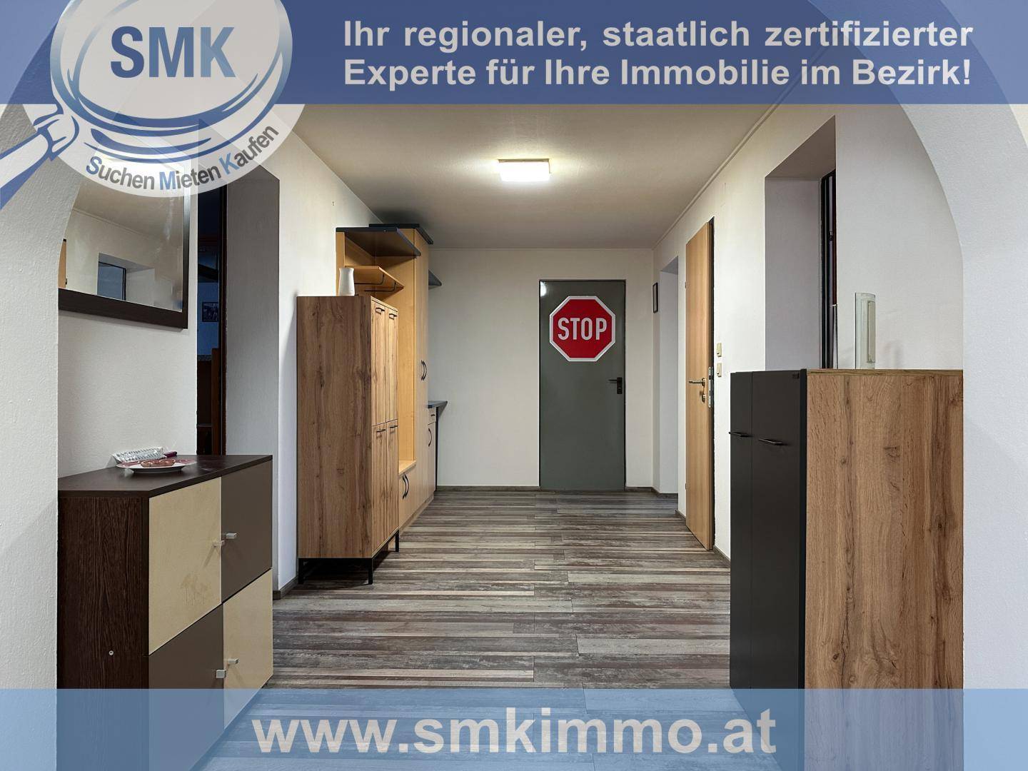 Moderner Flur mit Laminatboden, Garderobenmöbeln und einer Tür mit Stoppschild.
