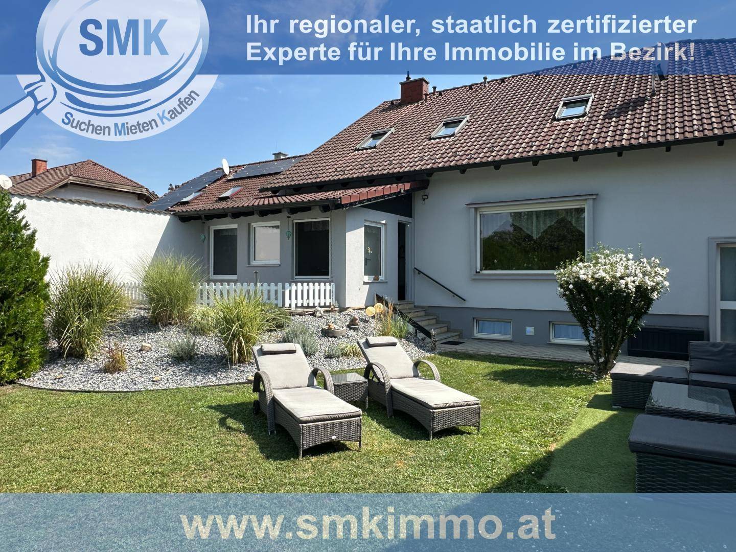 Ruhiger Gartenbereich mit Liegestühlen und gepflegter Bepflanzung hinter dem Wohnhaus.