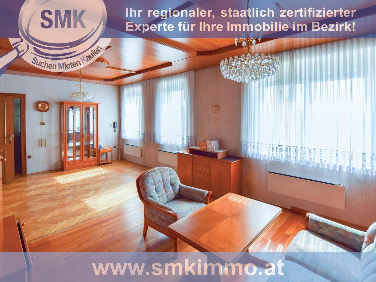 Helles Wohnzimmer mit Parkettboden, holzvertäfelter Decke und großen Fenstern mit Vorhängen.