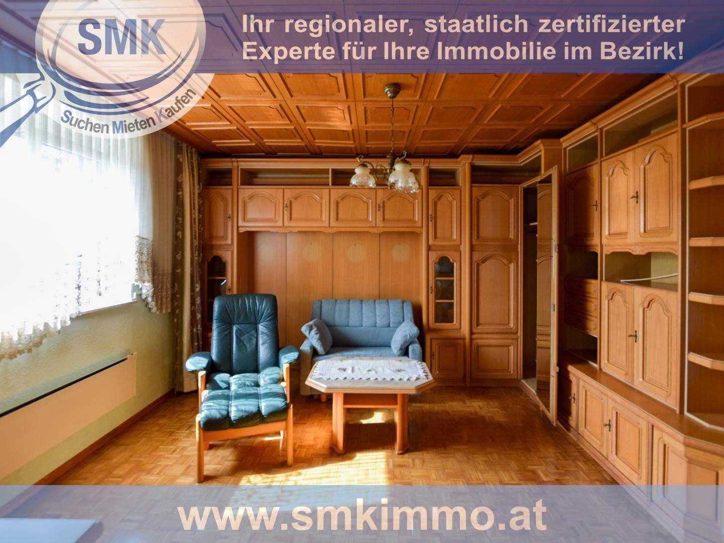 Gemütliches Wohnzimmer mit holzvertäfelter Decke, Einbauschränken und traditionellen Möbeln.