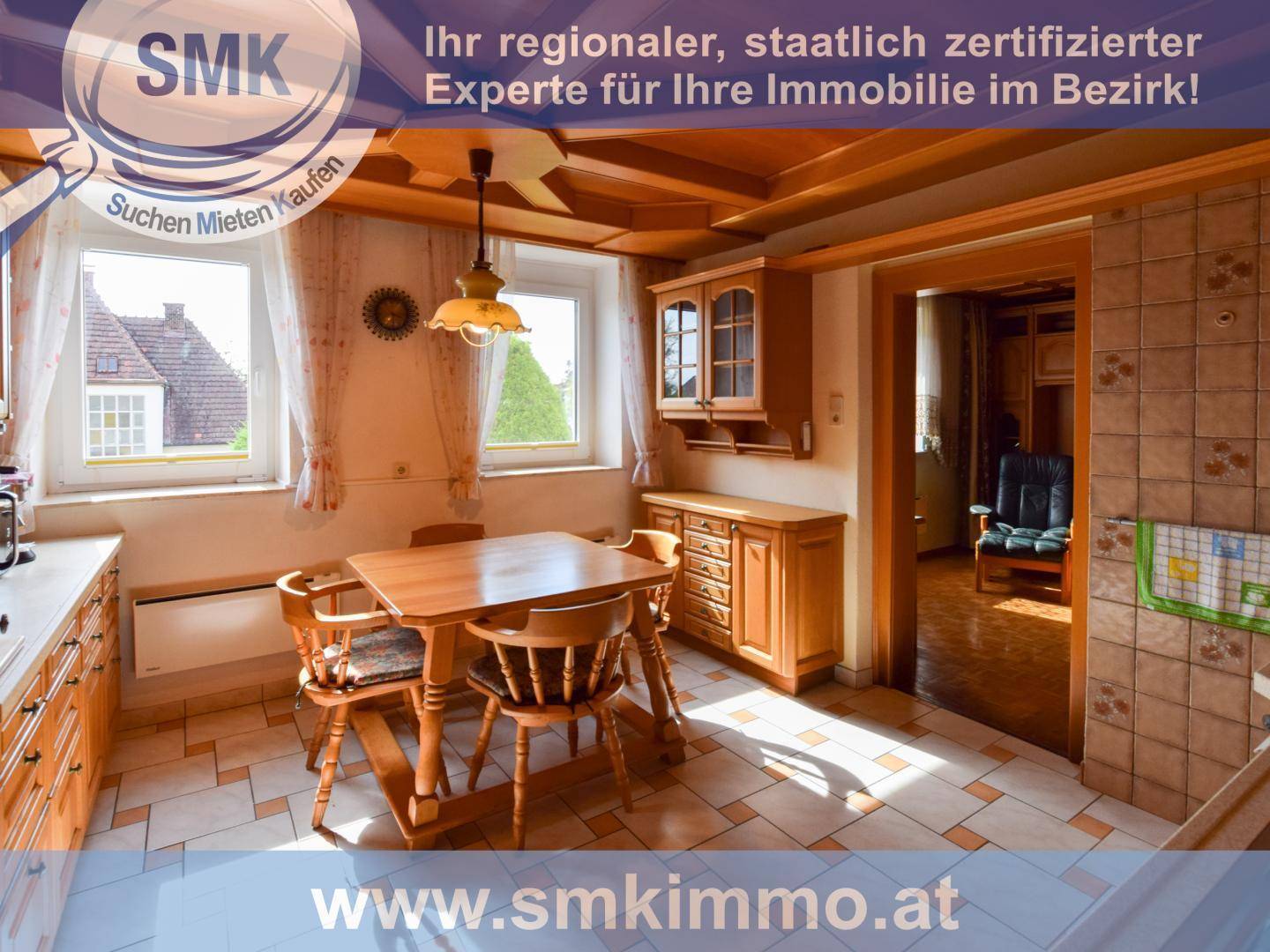 Rustikale Küche mit Holztisch, Stühlen und gemusterten Fliesenböden, angrenzend an einen weiteren Raum.
