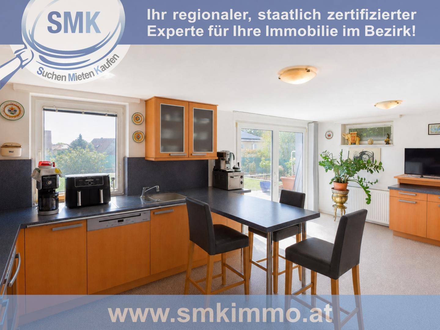 Helle Küche mit Essbereich, Holzschränken und direktem Zugang zum Garten.