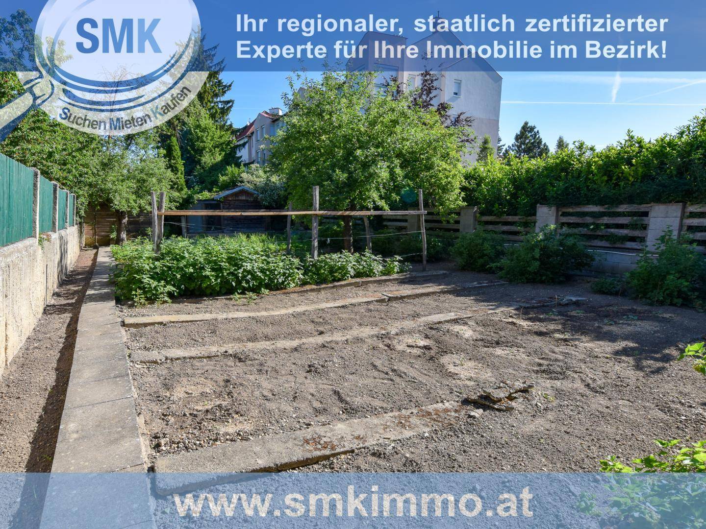 Gartenbereich mit vorbereiteten Beeten für den Anbau und einem schmalen Gehweg entlang der Grundstücksgrenze.