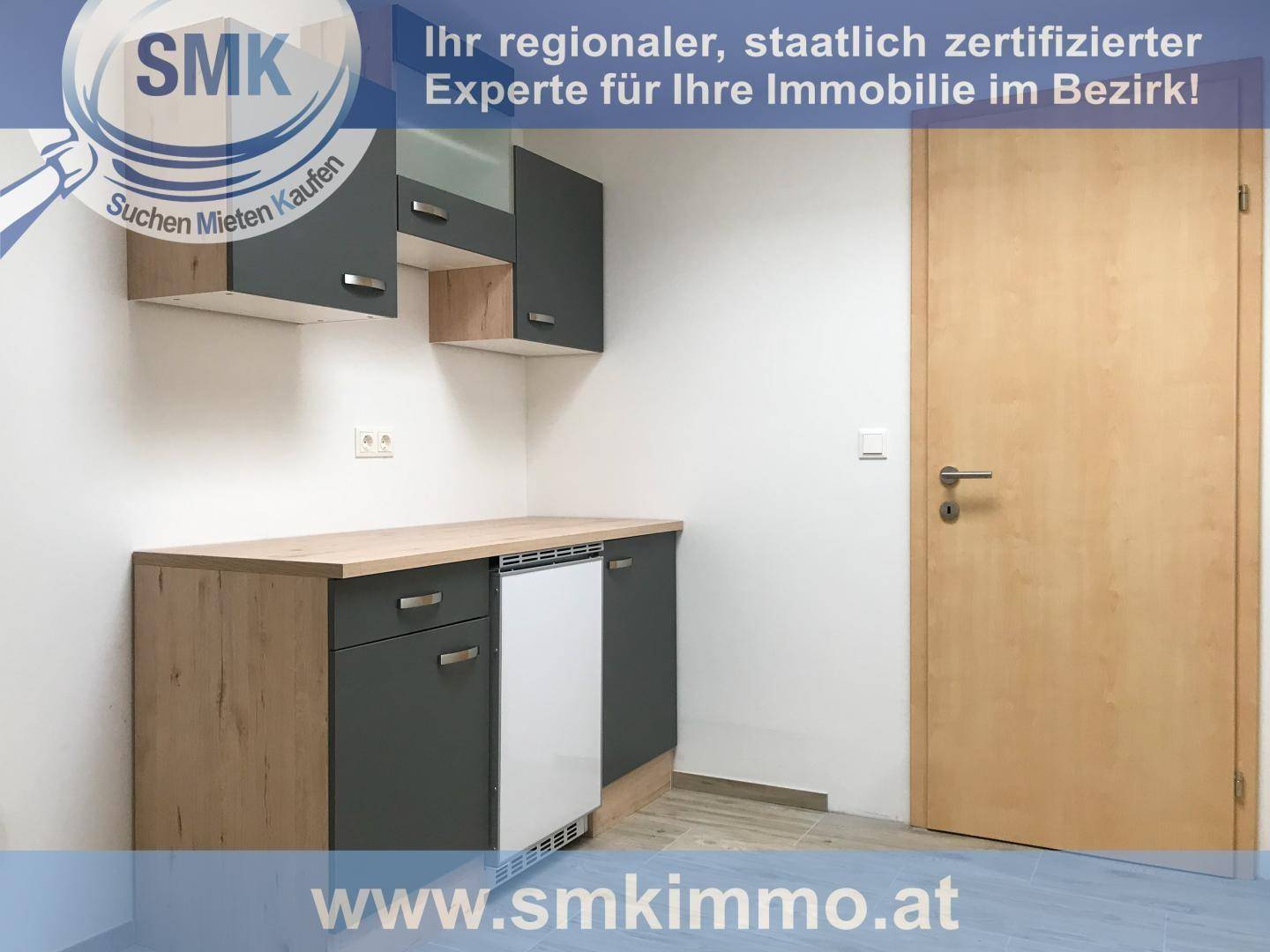 Kleine Küchenzeile mit modernen grauen und holzfarbenen Schränken, ideal für eine kompakte Wohnung.