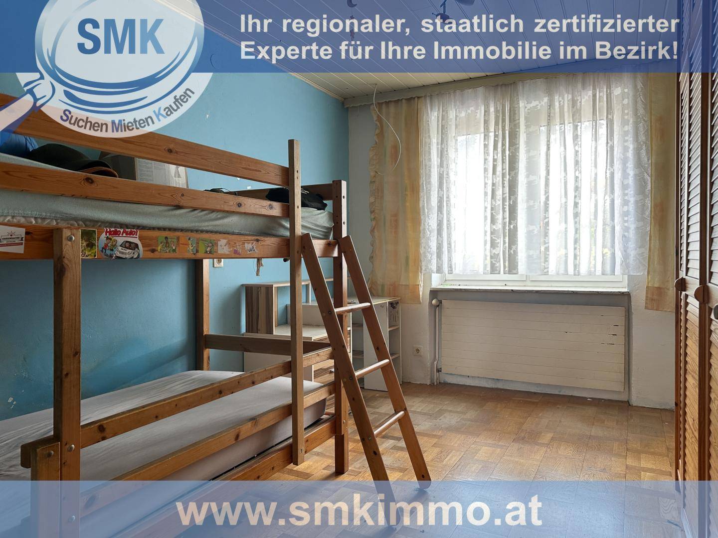 Kinderzimmer mit Etagenbett, blauen Wänden und einem Fenster mit Vorhängen.