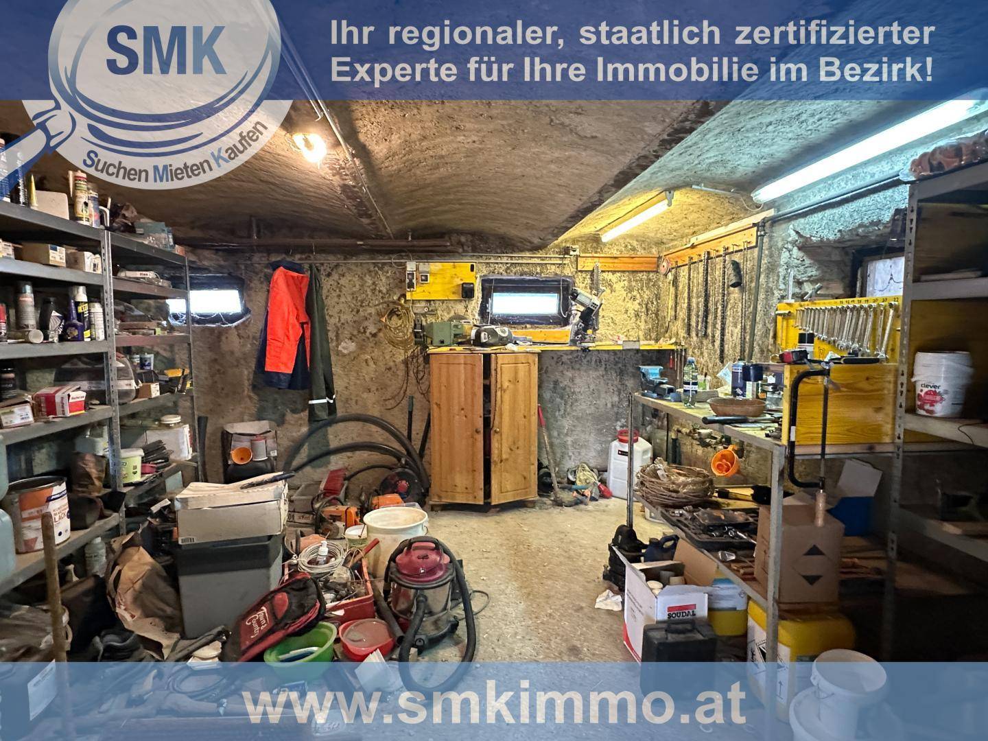Geräumiger Kellerraum, der als Werkstatt oder Lagerbereich genutzt wird, mit vielen Regalen.