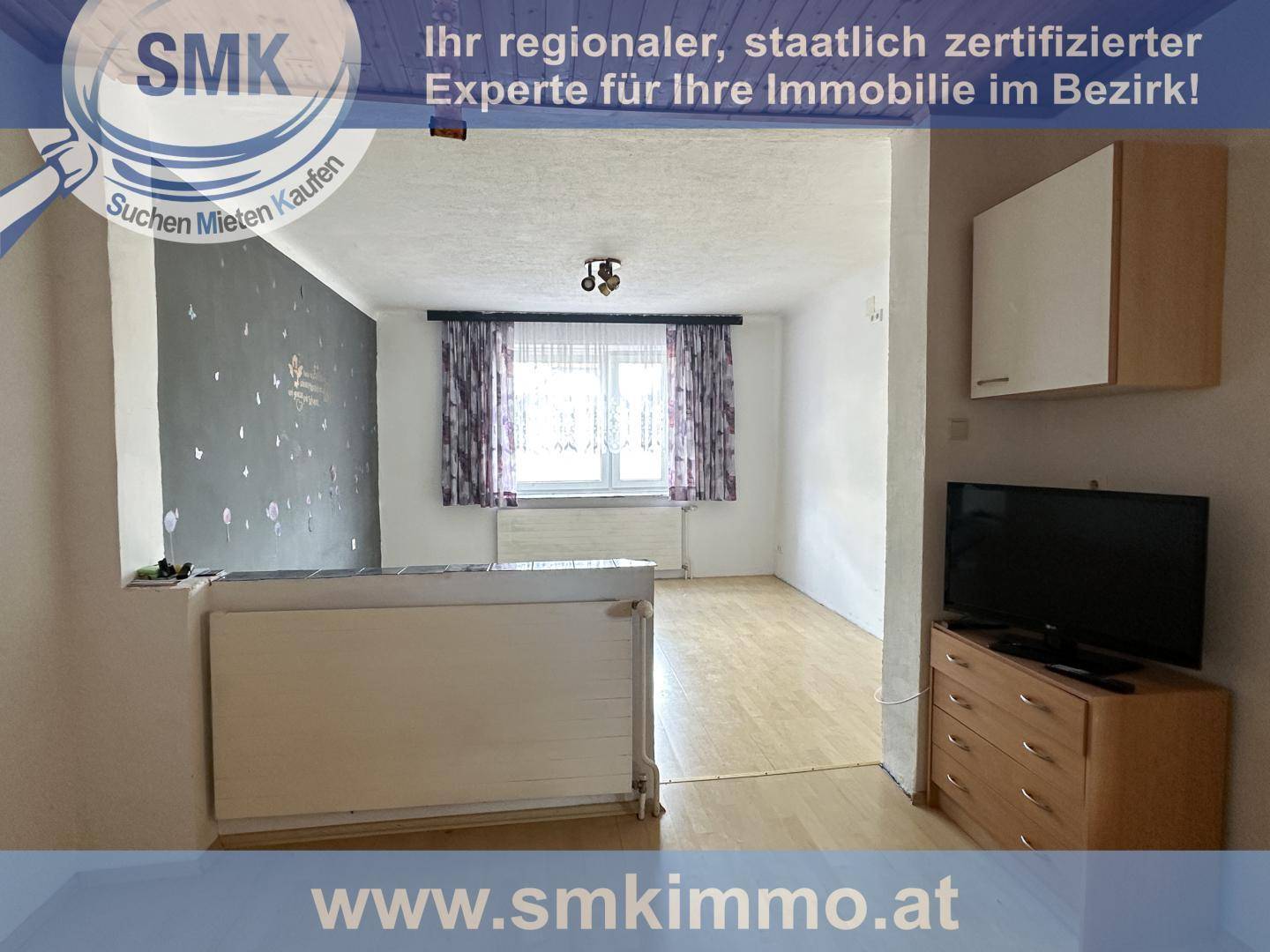 Heller Wohnraum mit Laminatboden, Fenster und Heizkörper, bereit zur individuellen Gestaltung.