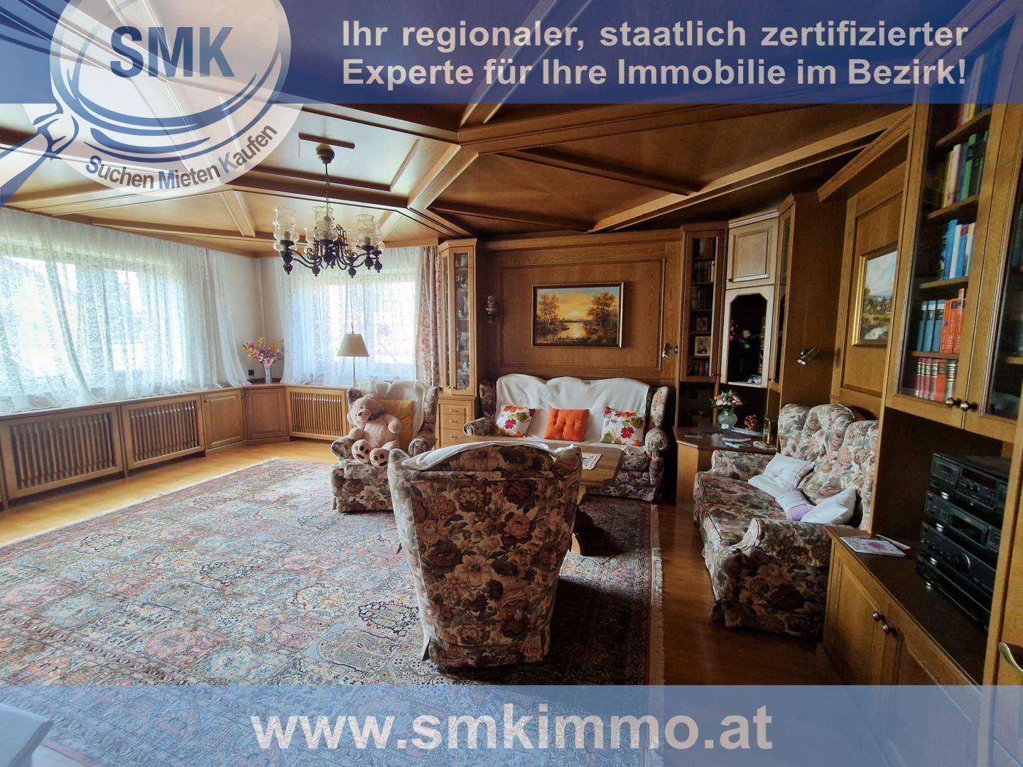Geräumiges Wohnzimmer im traditionellen Stil mit Holzvertäfelung, Kassettendecke und großen Fenstern.