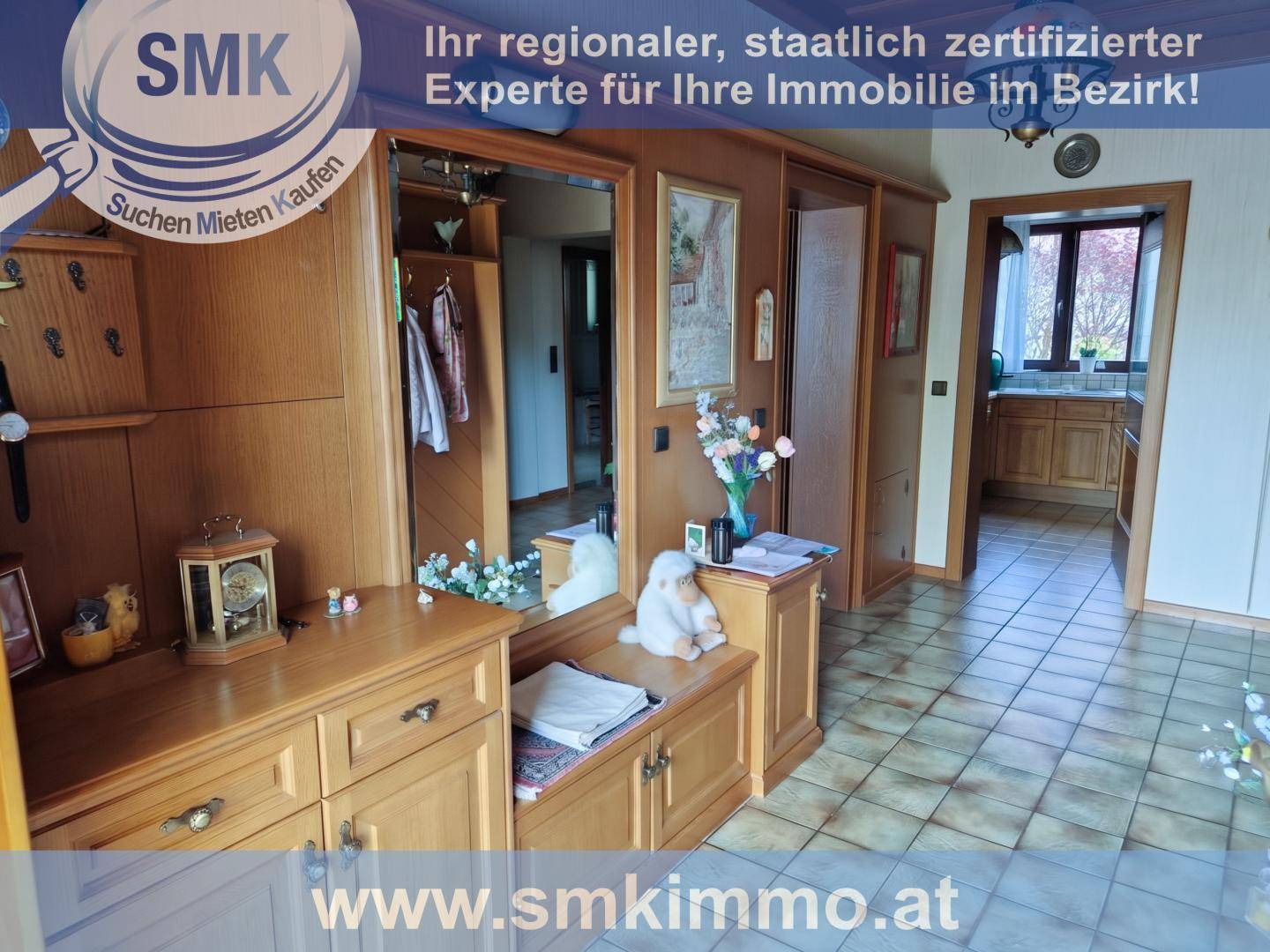 Geräumiger Flur mit Holzmöbeln, großem Spiegel und gemusterten Fliesenboden.