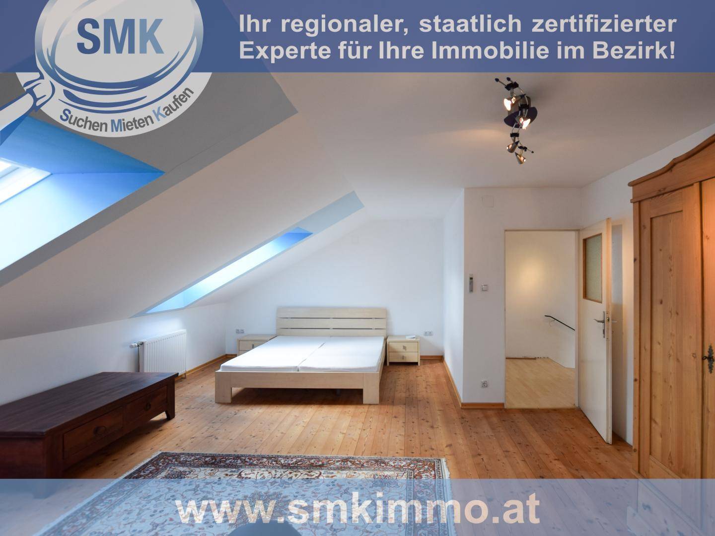 Gemütliches Schlafzimmer im Dachgeschoss mit Dachschrägen, Holzboden und Dachfenstern.
