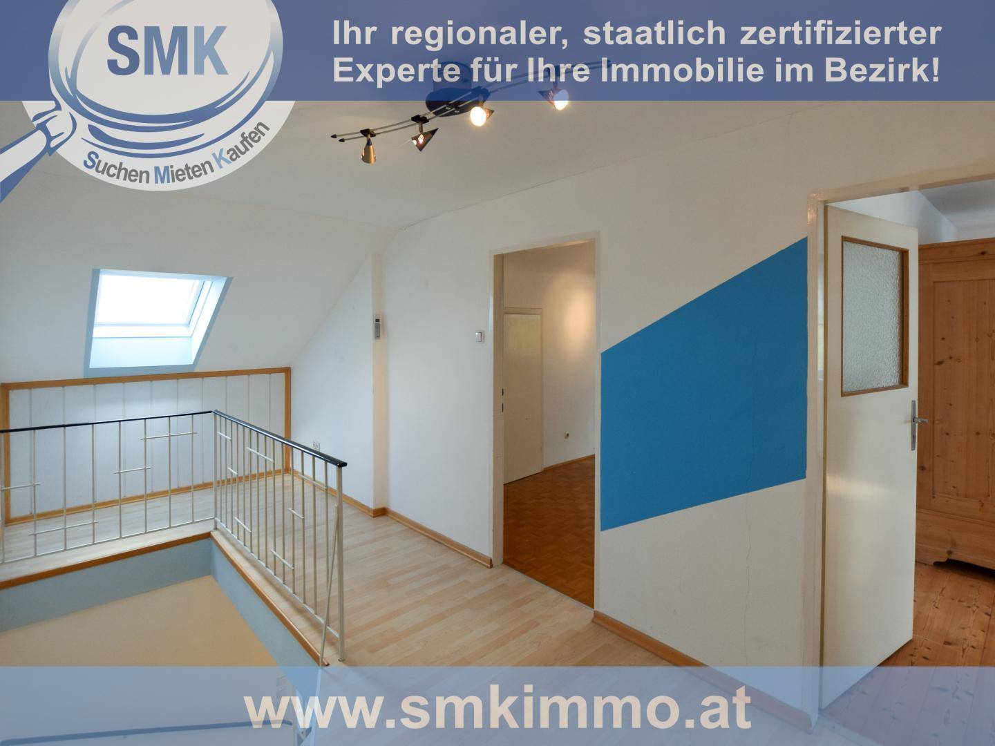 Heller Flur im Obergeschoss mit Dachfenster, Holzfußboden und Geländer.