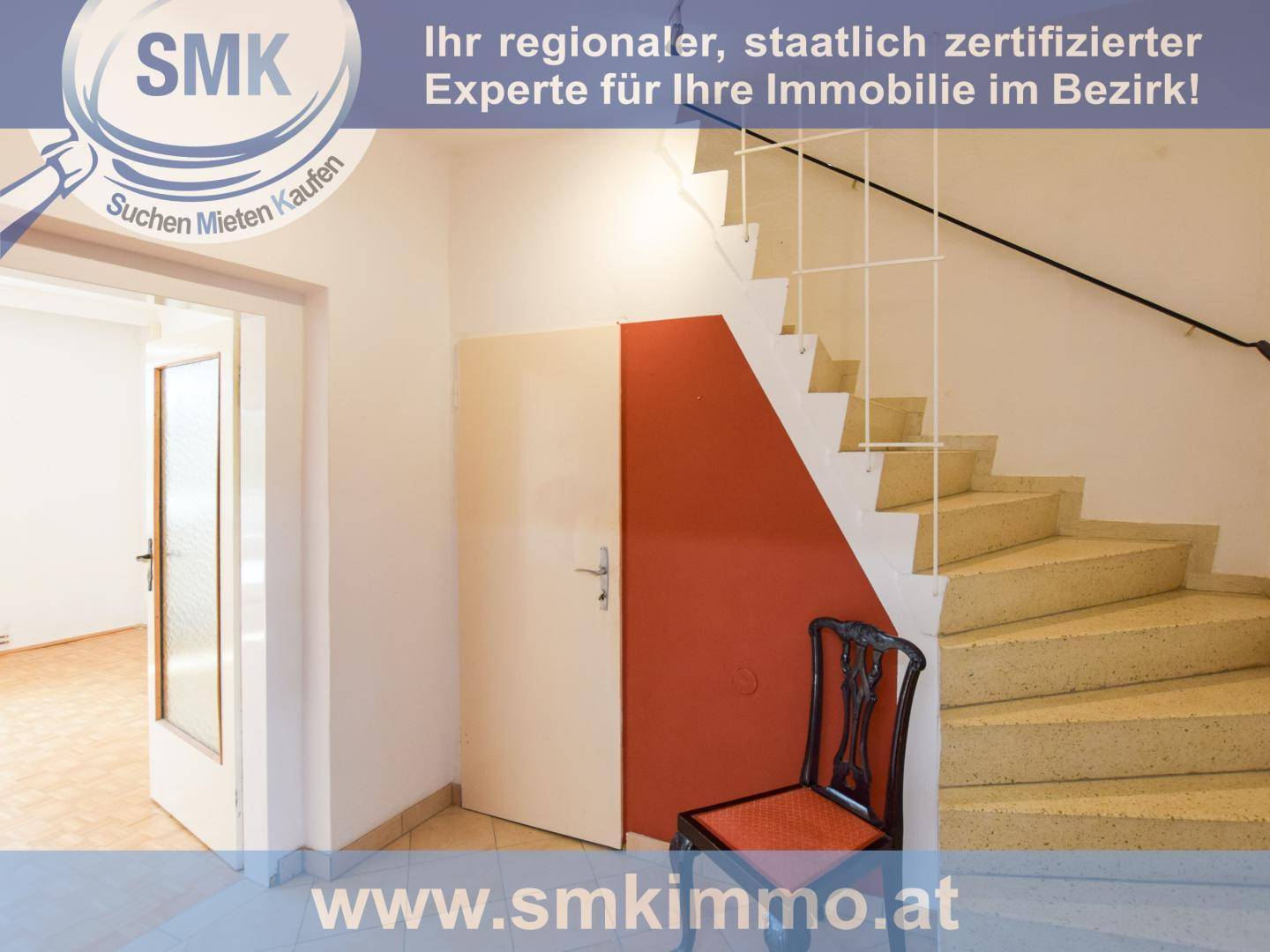 Eingangsbereich mit Treppe, roter Akzentwand und Zugang zu weiteren Räumen.