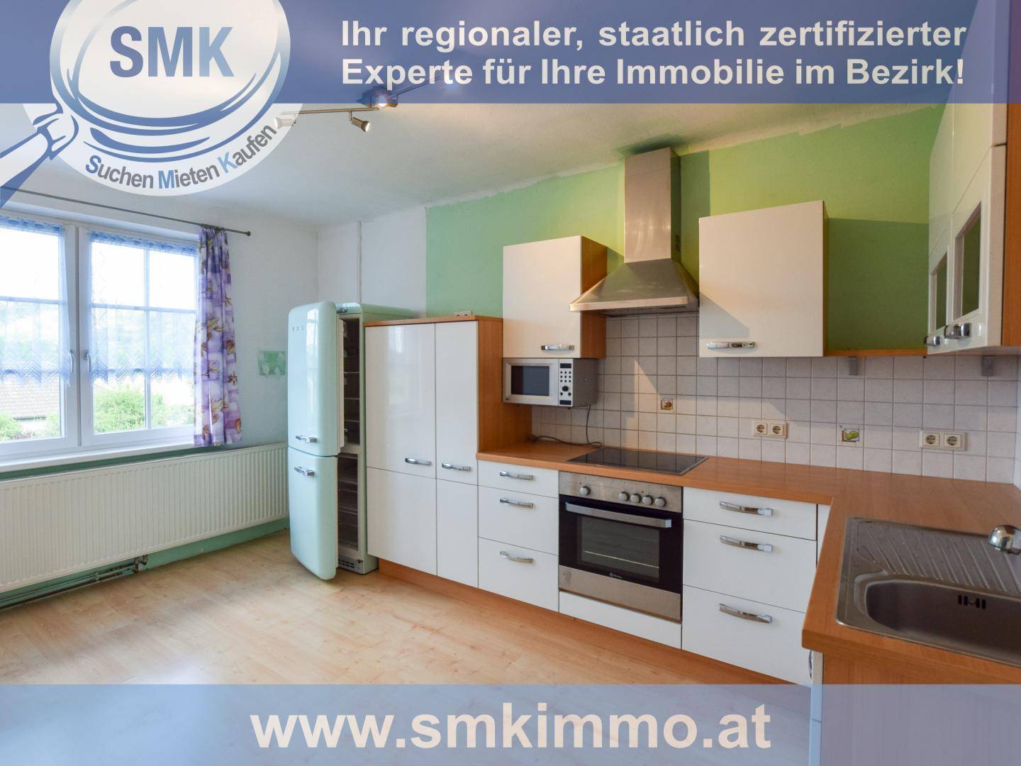 Moderne Küche mit weißen Schränken, Holzarbeitsplatten und integrierten Geräten.