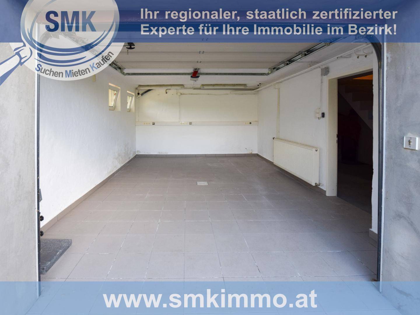 Geräumige und helle Garage mit Fliesenboden und Heizkörper.