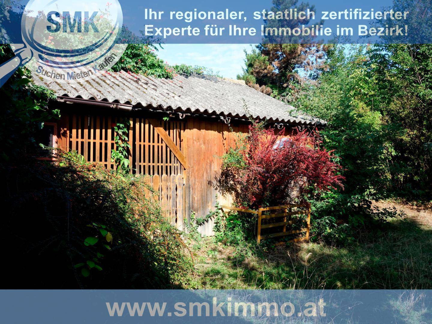 Rustikaler Holzschuppen im Grünen, umgeben von dichter Vegetation und Bäumen.