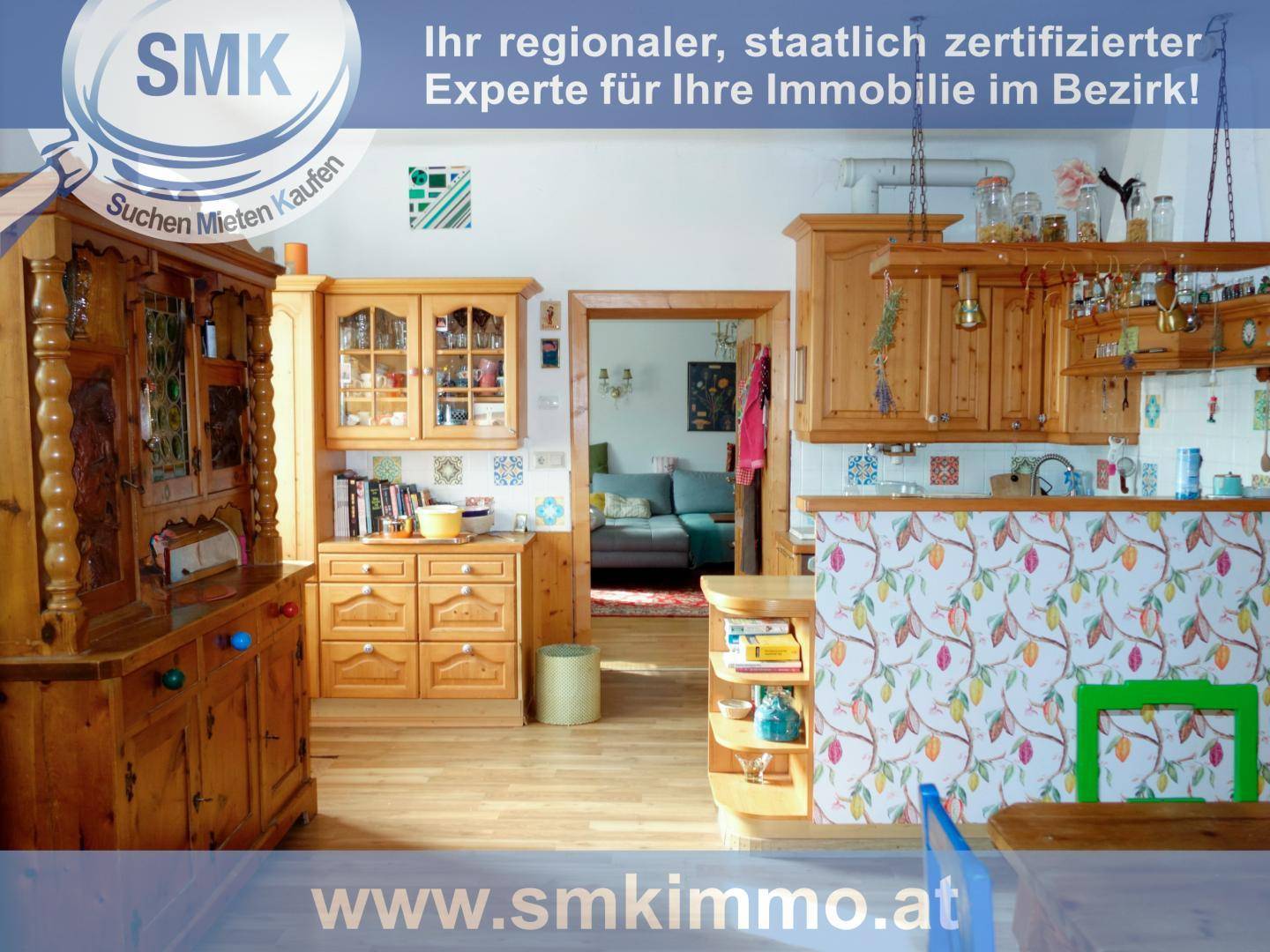 Rustikale Holzküche mit traditionellen Schränken und Blick in den angrenzenden Wohnbereich.