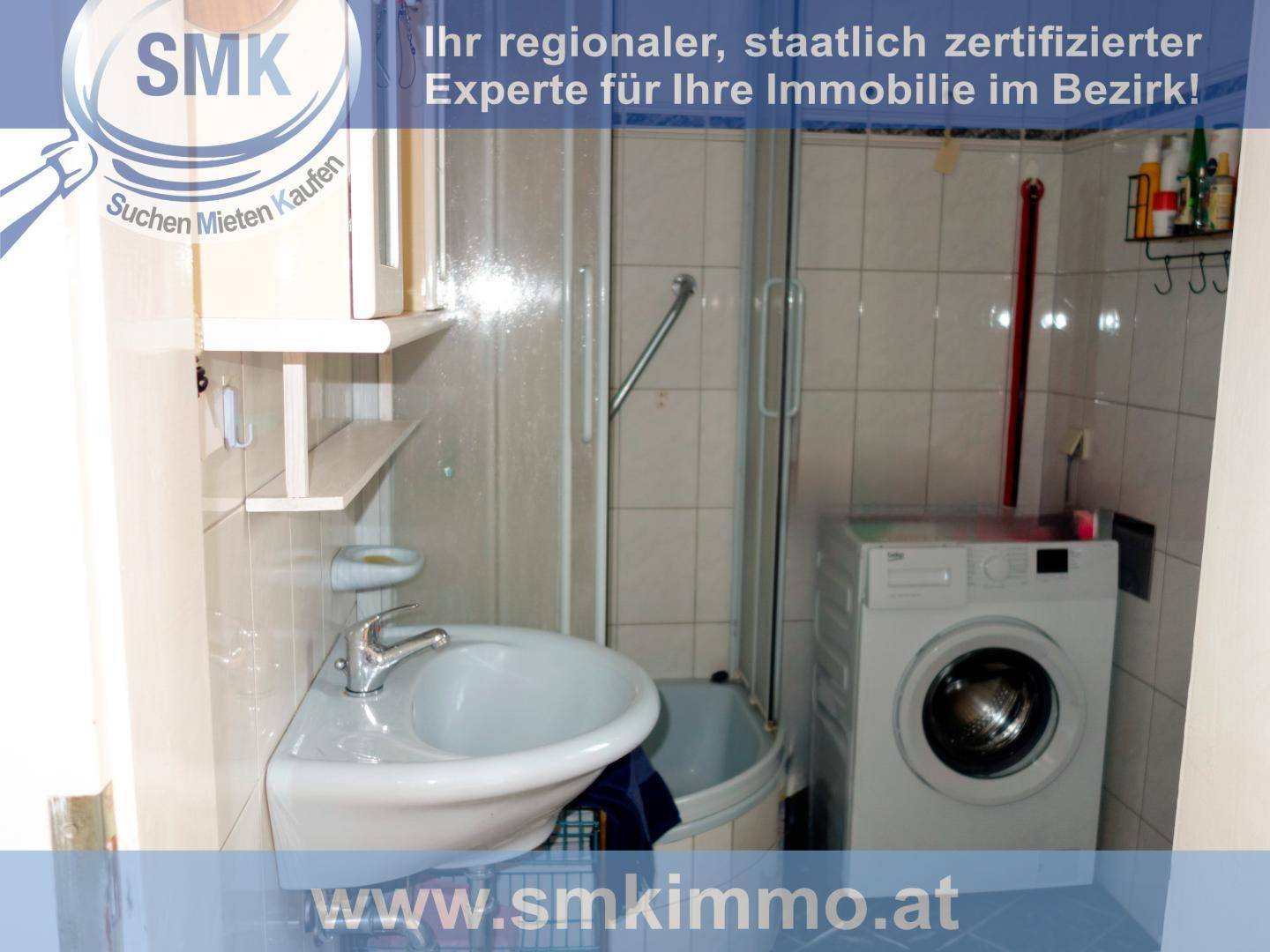 Kleines Badezimmer mit Dusche, Waschbecken und integrierter Waschmaschine für praktische Nutzung.