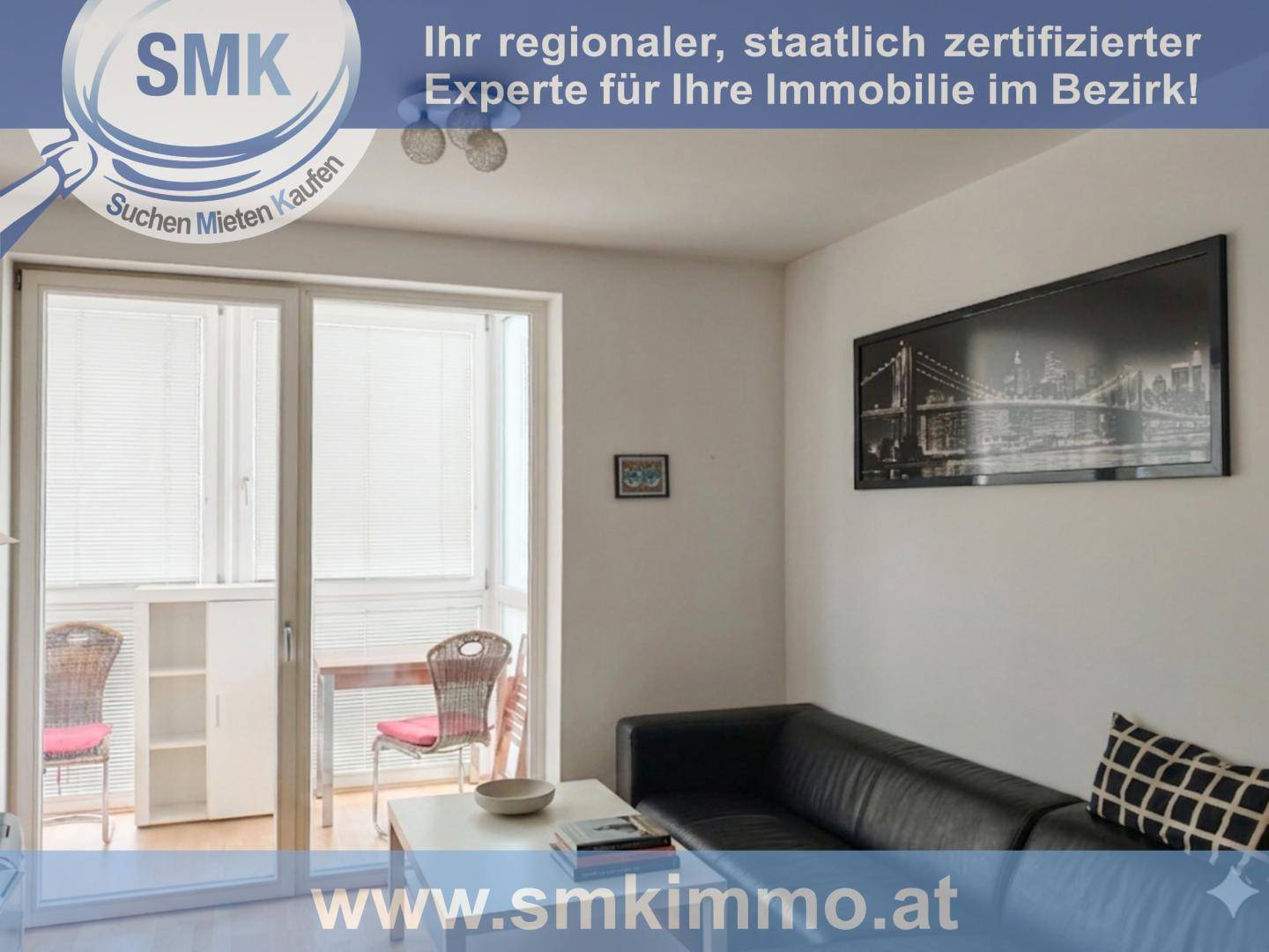 Helles Wohnzimmer mit schwarzem Sofa, Couchtisch und Zugang zu einem Balkon oder einer Loggia.