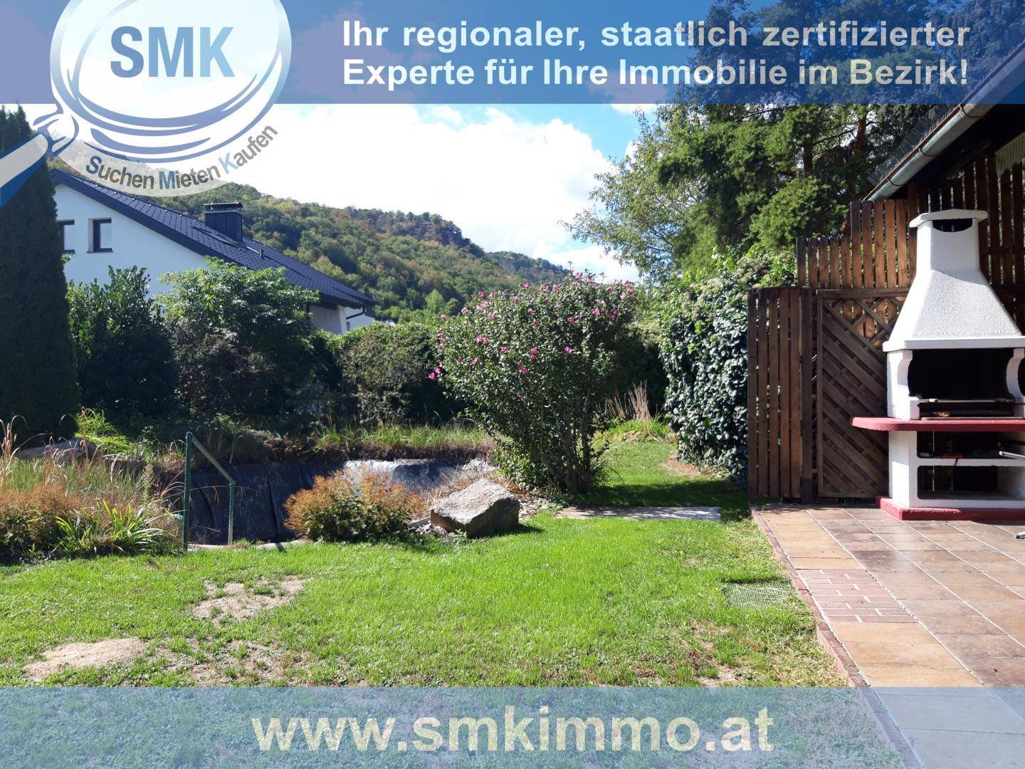 Großer Gartenbereich mit gemauertem Grillplatz und Blick auf die umliegende Landschaft.