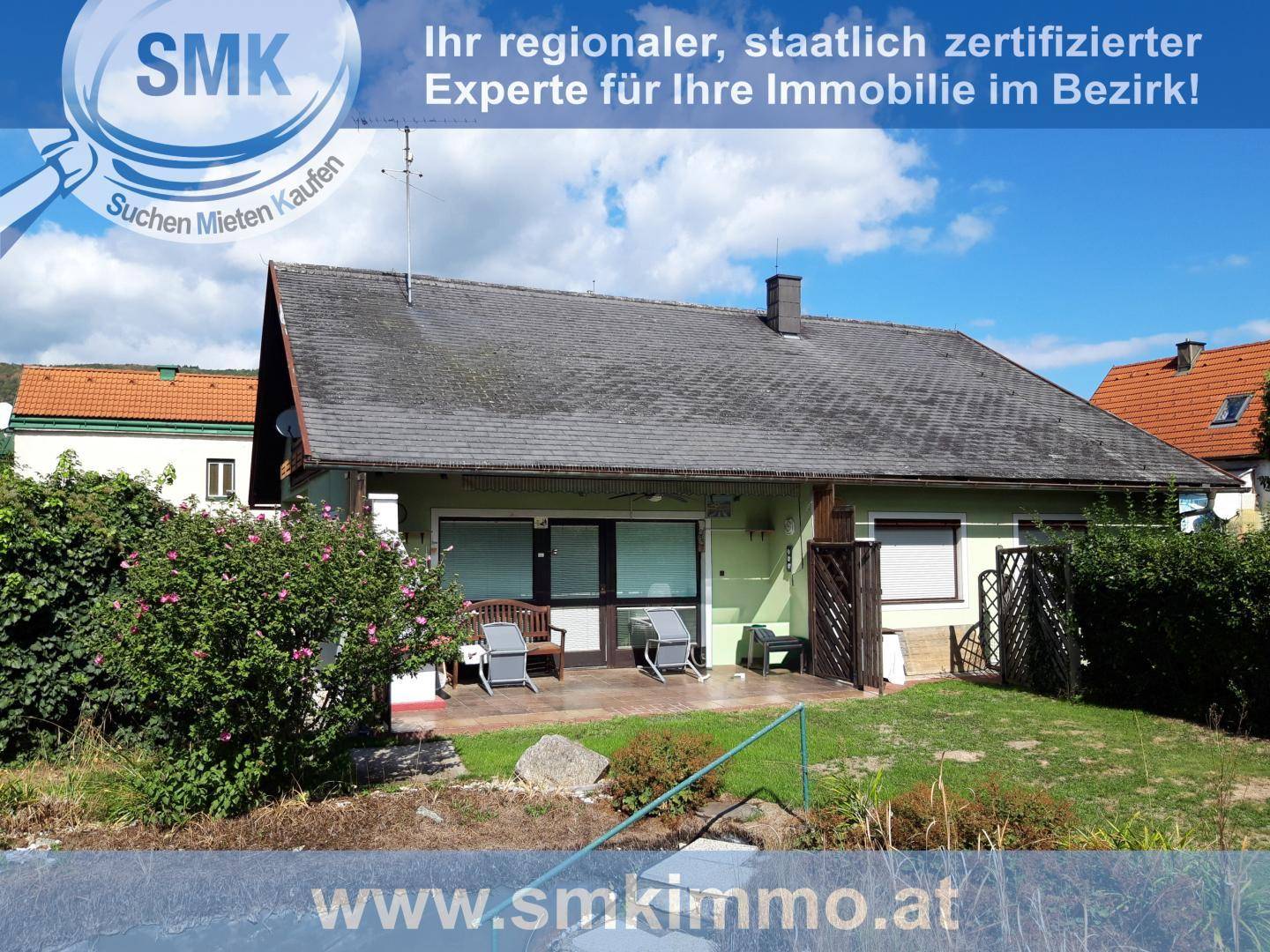 Rückseite des Hauses mit kleiner Terrasse und Gartenblick, ideal für entspannte Stunden im Freien.