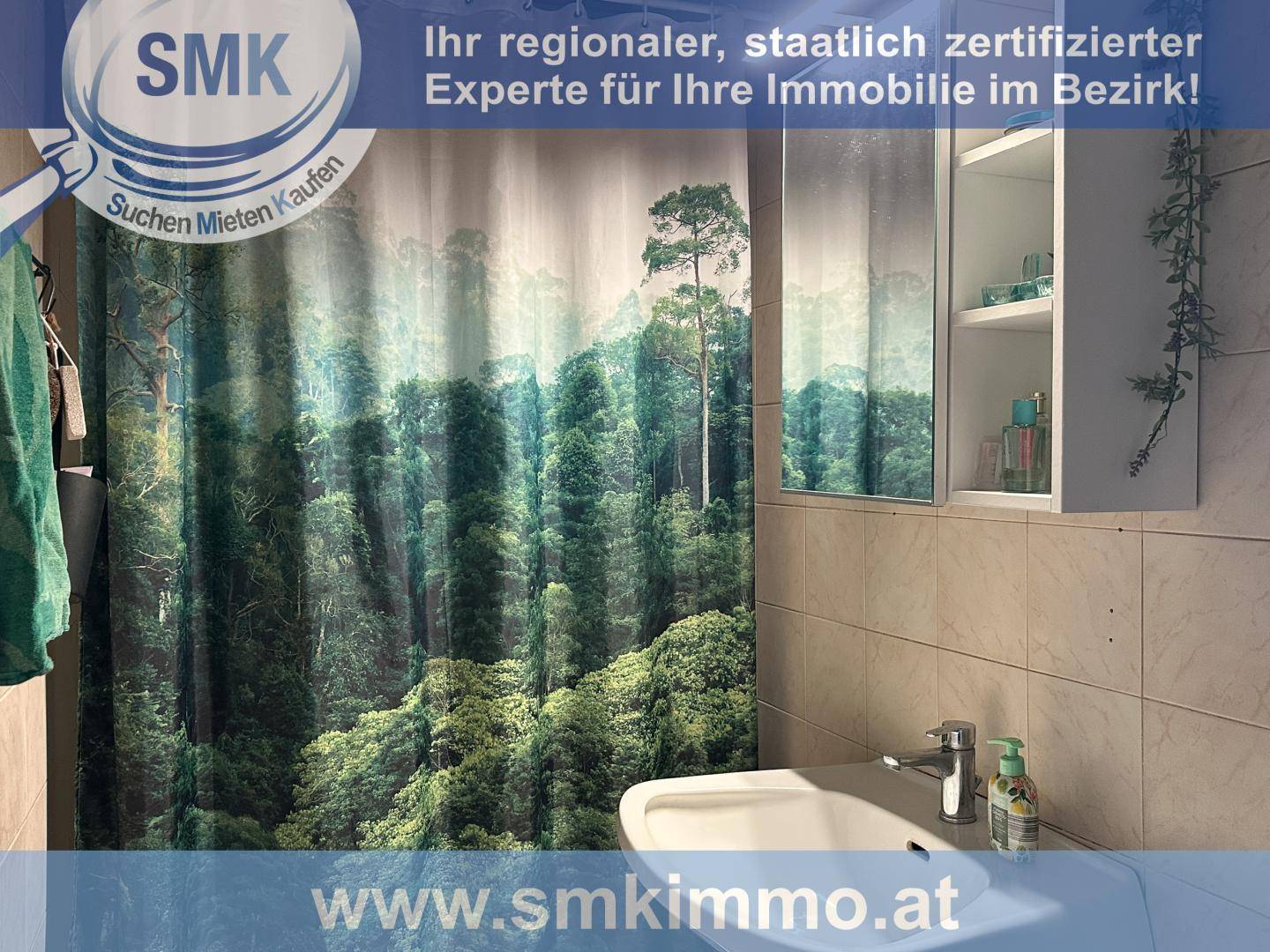 Badezimmer mit Waschbecken, Spiegelschrank und Duschvorhang mit Waldmotiv.