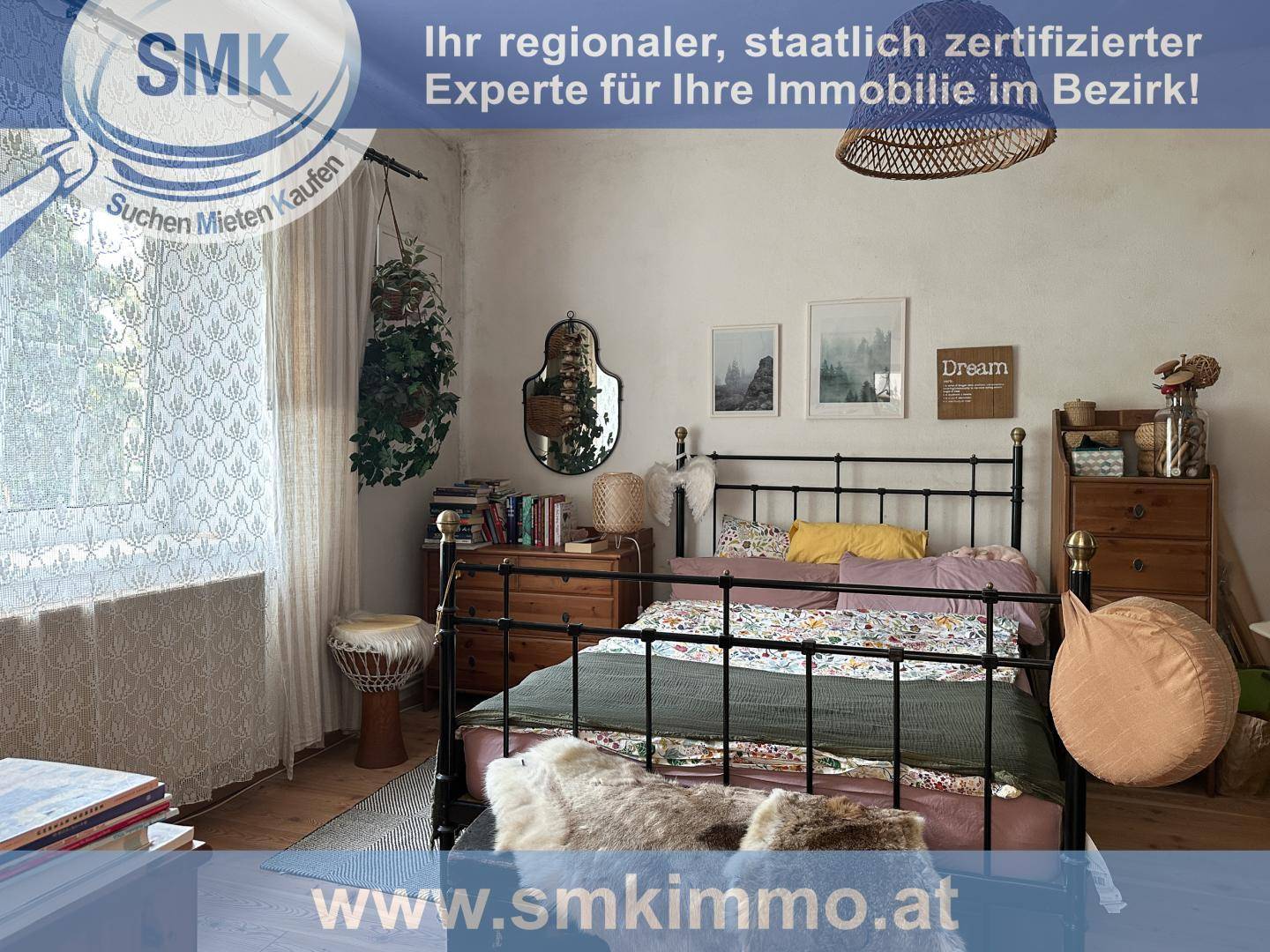 Gemütliches Schlafzimmer mit Metallbett, Holzmöbeln und natürlichem Lichteinfall.