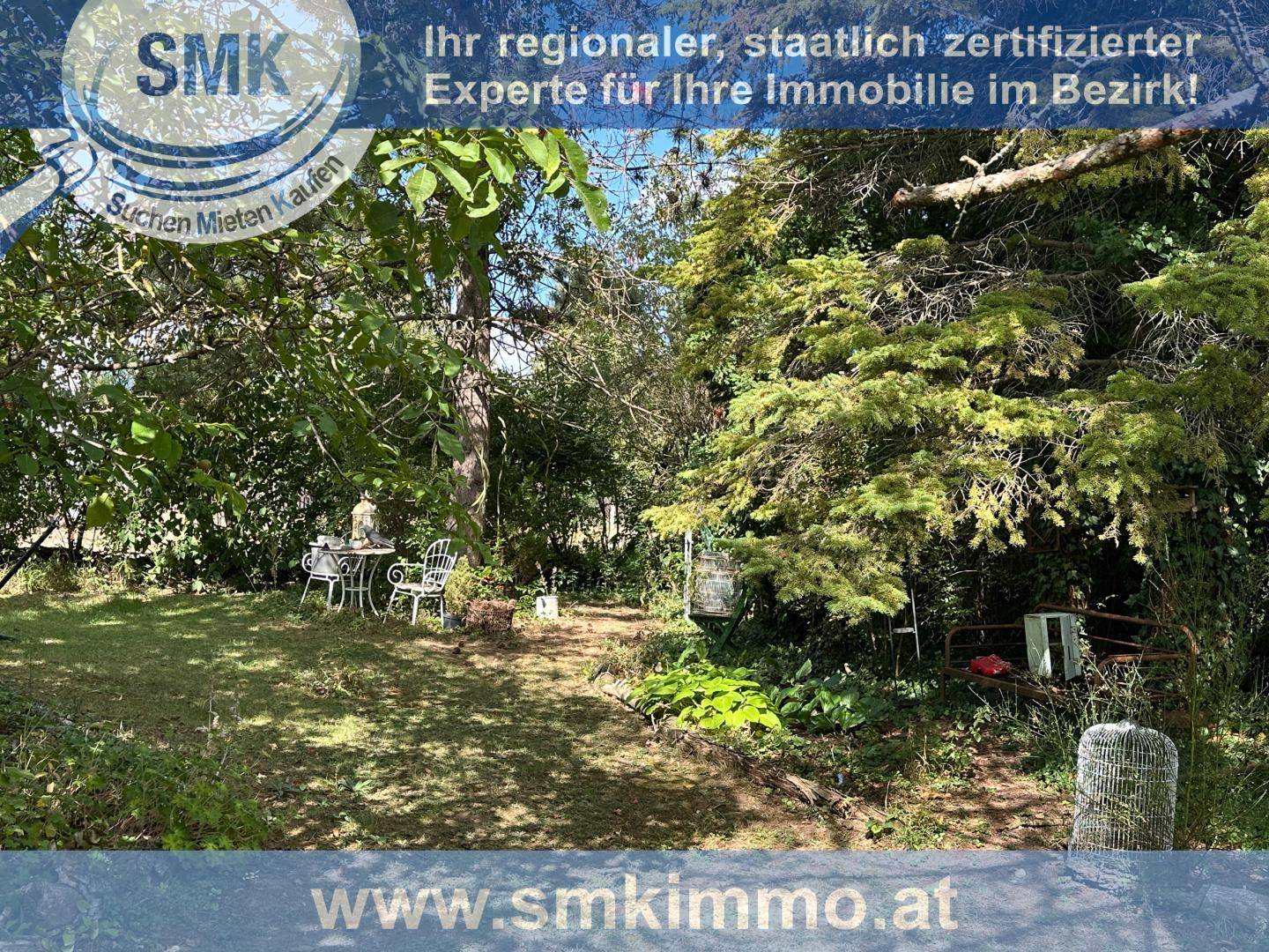 Ruhiger Gartenbereich mit Sitzgelegenheiten unter Bäumen, ideal zum Entspannen.