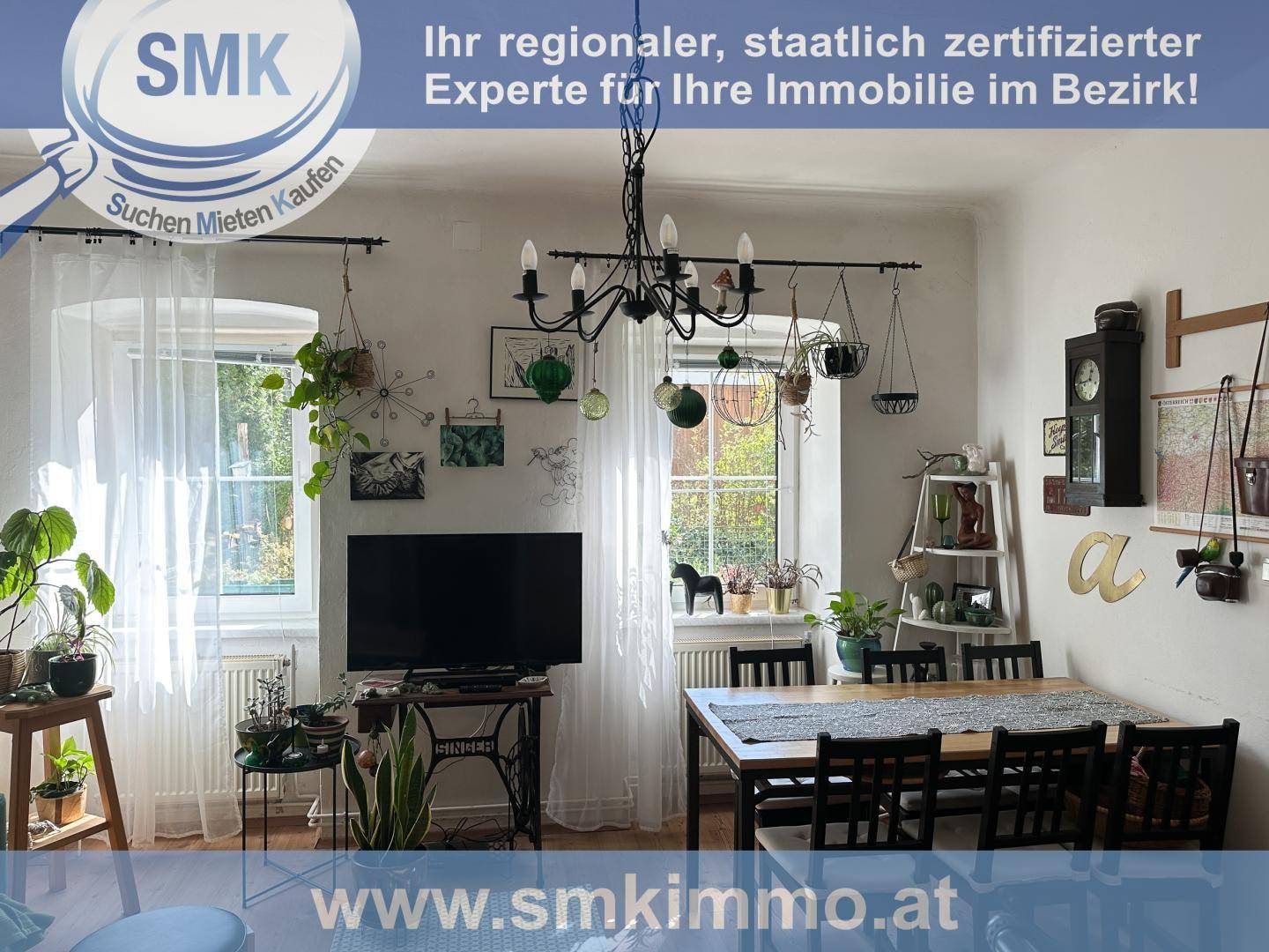 Gemütlicher Wohn- und Essbereich mit Esstisch, Fernseher und vielen Zimmerpflanzen.