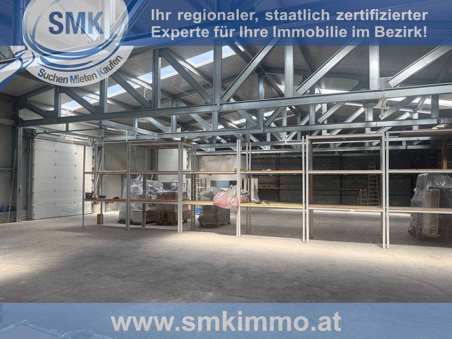 Industrieller Lagerraum mit hohen Decken, sichtbaren Metallträgern und umfangreichen Regalsystemen.
