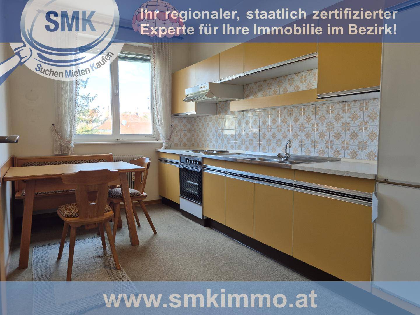 Funktionale Küche mit gelben Schränken, gemusterten Fliesen und einem gemütlichen Essbereich am Fenster.