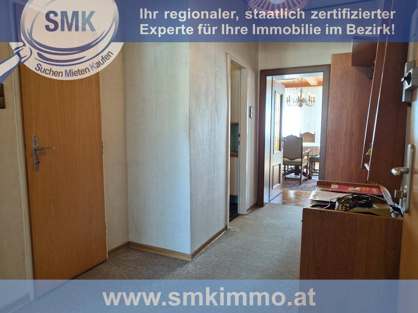 Heller Flur mit Teppichboden und Zugang zu einem traditionell eingerichteten Esszimmer.