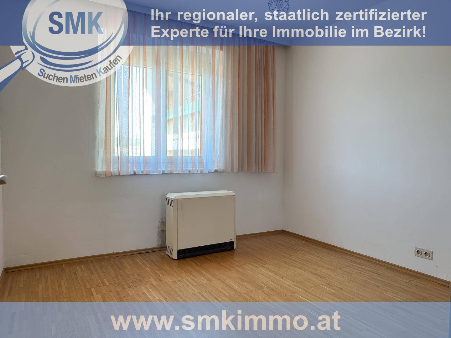 Helles Schlafzimmer mit Holzfußboden, Fenster und Heizkörper.