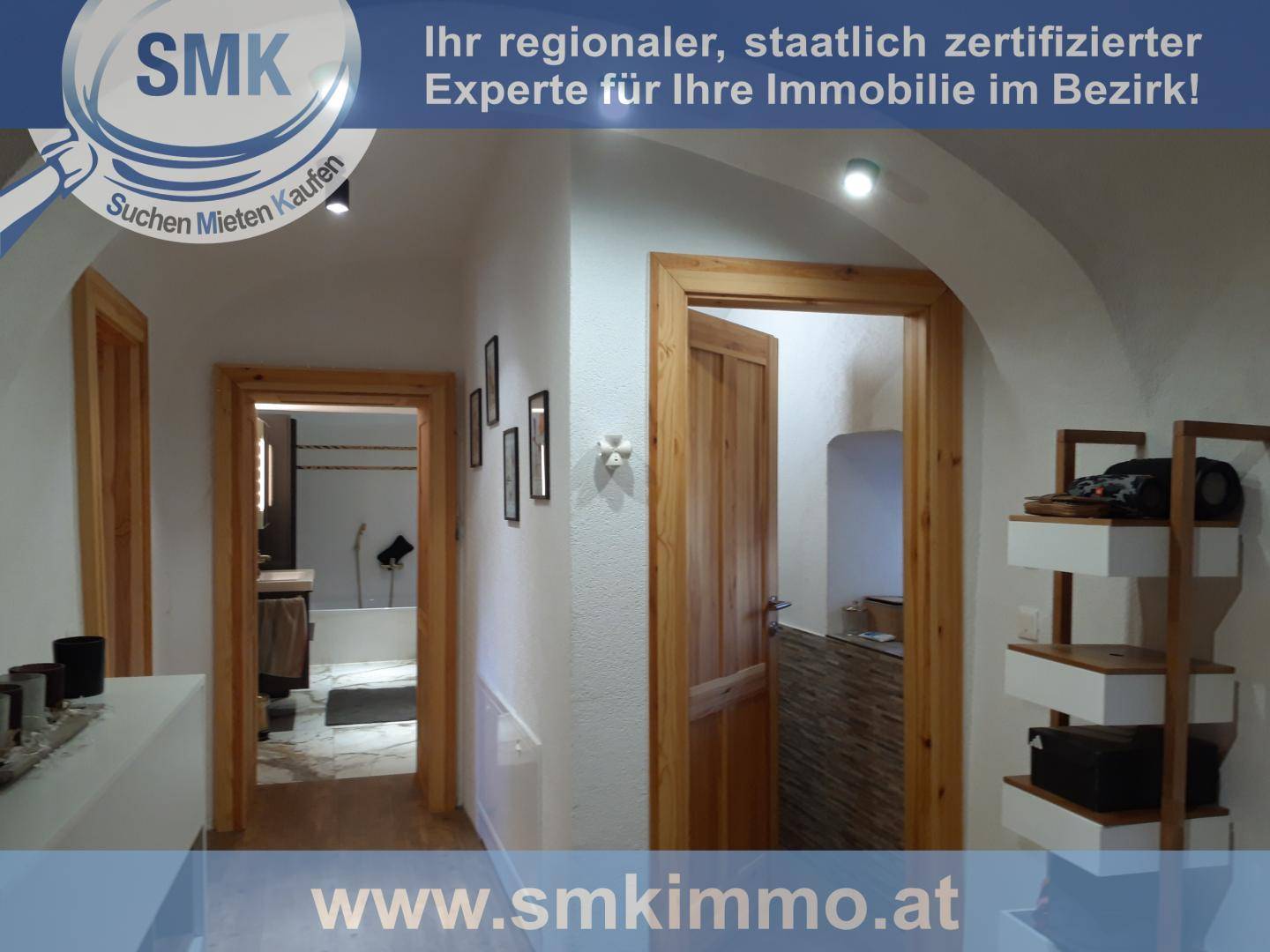 Heller Flur mit Holztüren, gewölbter Decke und Blick in ein Badezimmer.