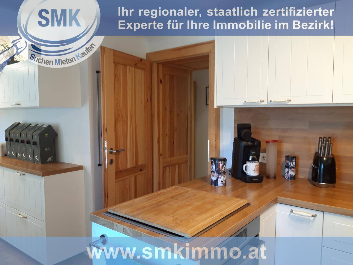 Moderne Küche mit weißen Schränken, Holzarbeitsplatte und Holztür.