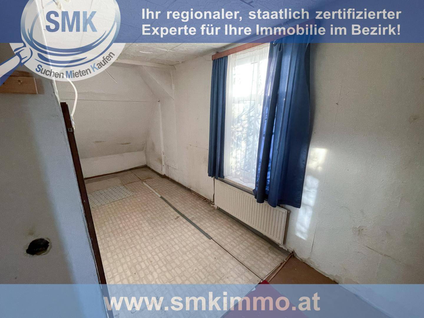 Kleines Zimmer im Dachgeschoss mit schräger Decke und Fenster, das eine Modernisierung erfordert.