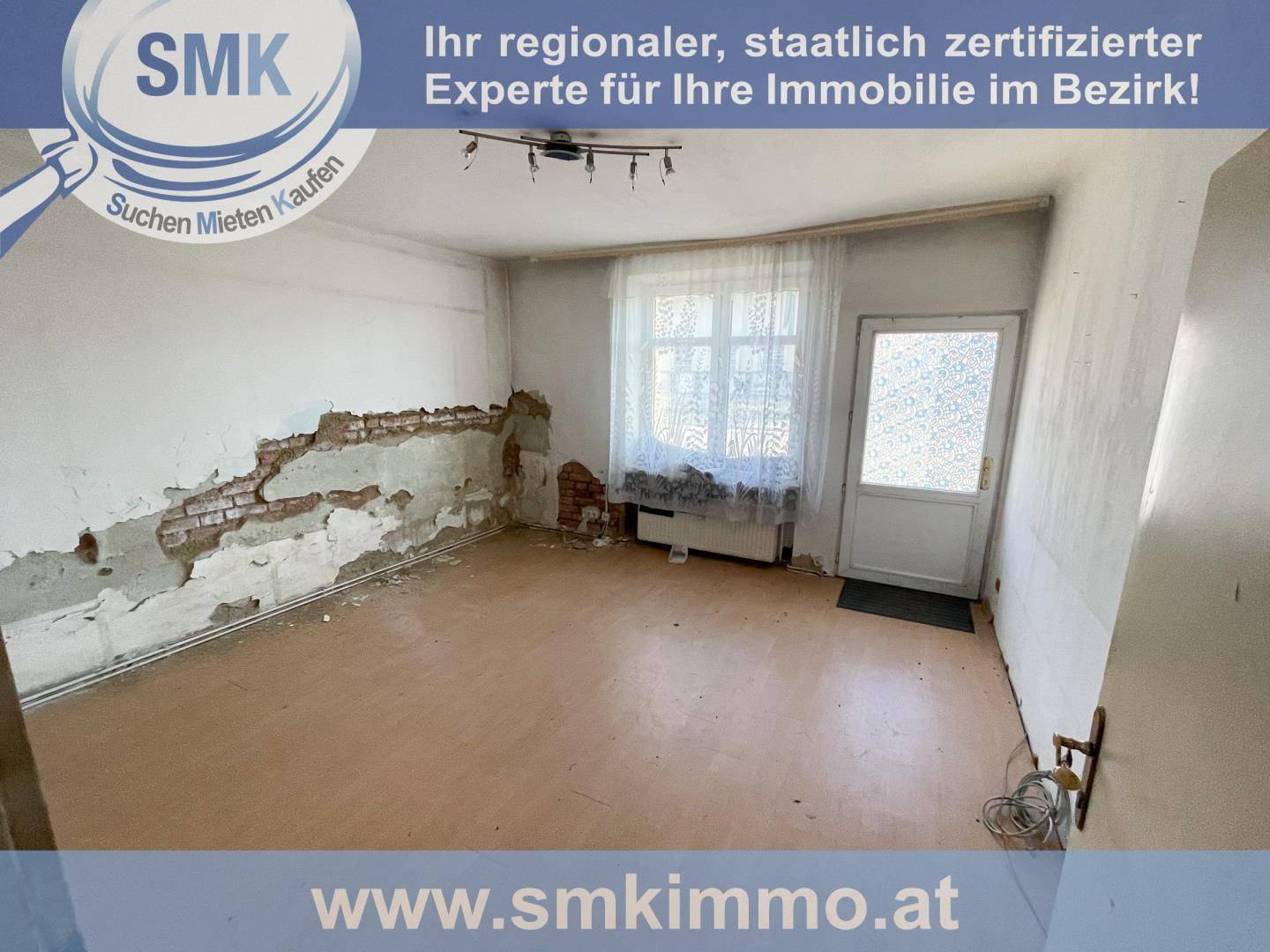 Zimmer in schlechtem Zustand mit freiliegendem Mauerwerk und deutlichem Renovierungsbedarf.