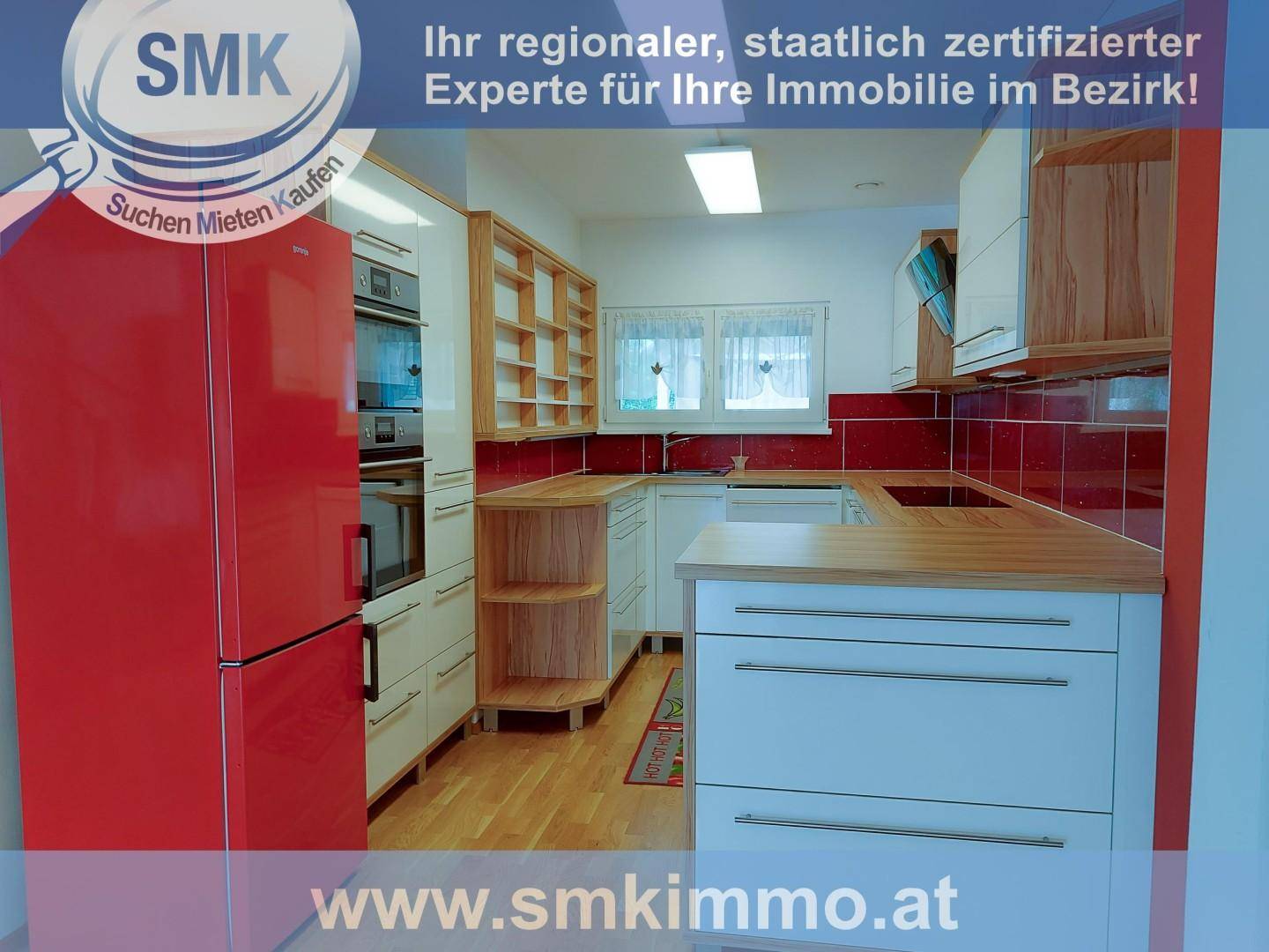 Funktionale Küche mit weißen Schränken, Holzarbeitsplatten, roten Fliesen und großem Kühlschrank.