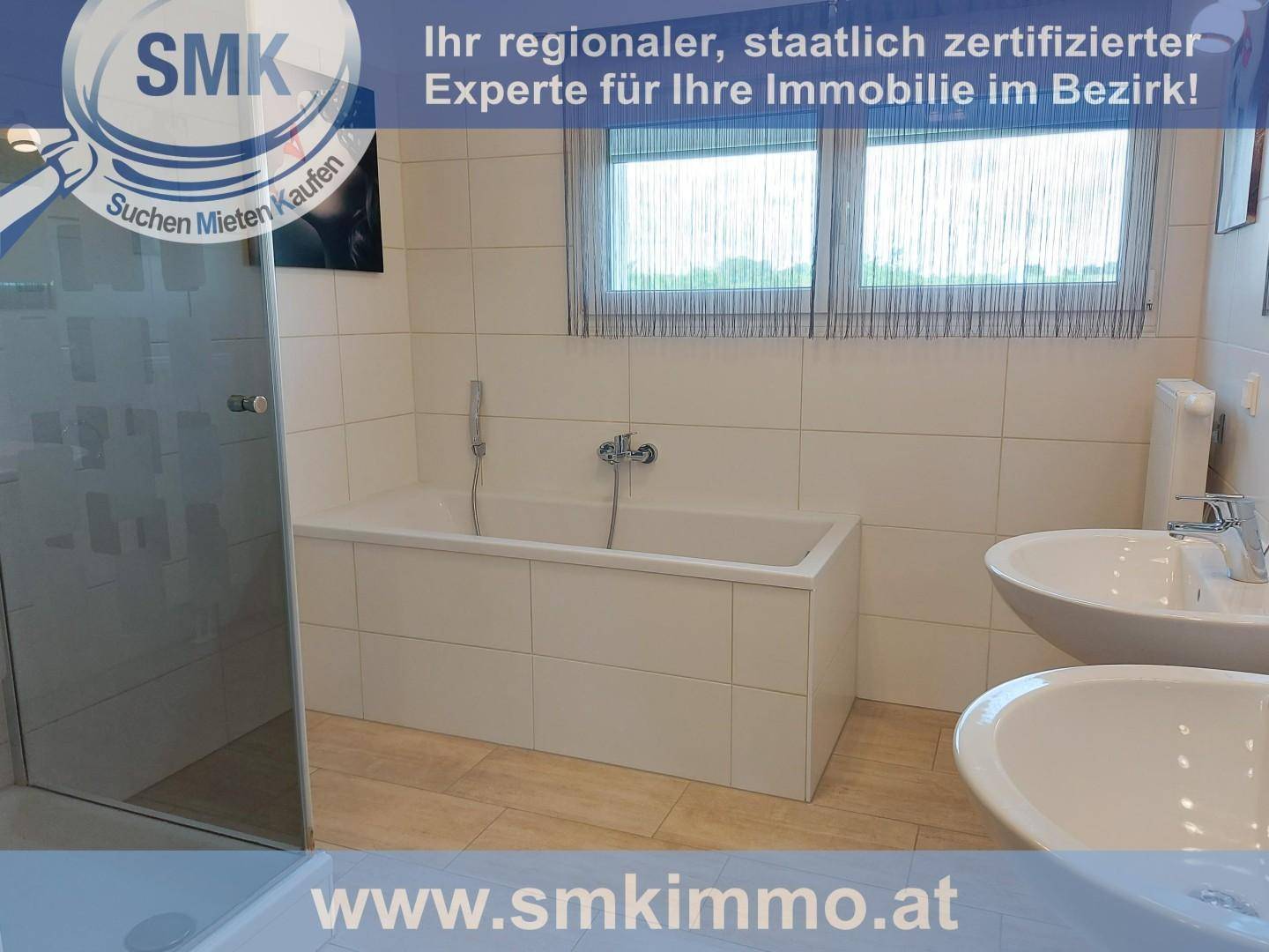 Modernes Badezimmer mit Badewanne, zwei Waschbecken und einer separaten Duschkabine.
