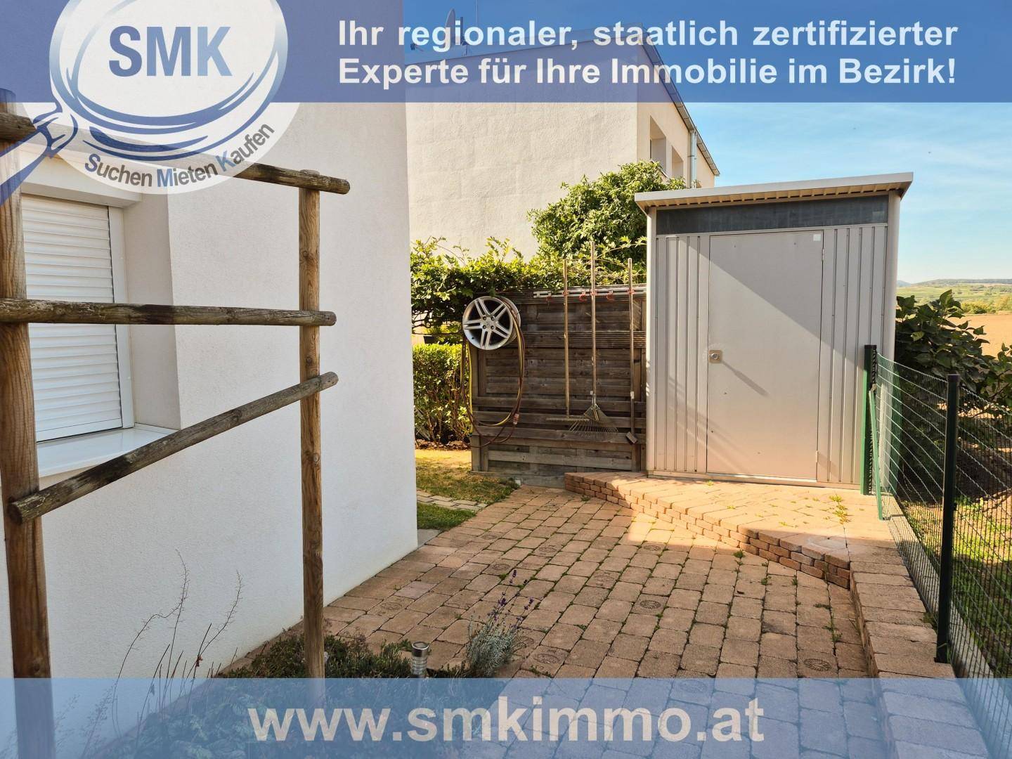 Gepflasterter Außenbereich mit einem praktischen Gartenschuppen und Gartenwerkzeugen.