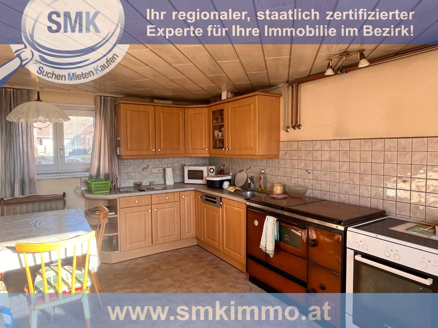 Traditionelle Küche mit Holzschränken, gefliestem Spritzschutz und einem klassischen Holzofen.