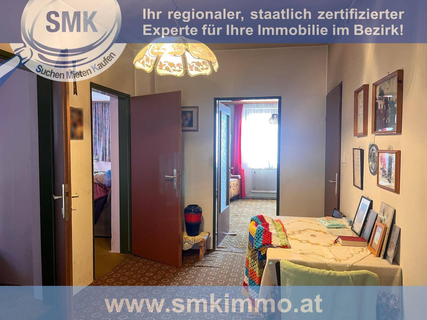 Flur mit mehreren Türen, gemustertem Teppichboden und einem kleinen Tisch mit Dekoration.