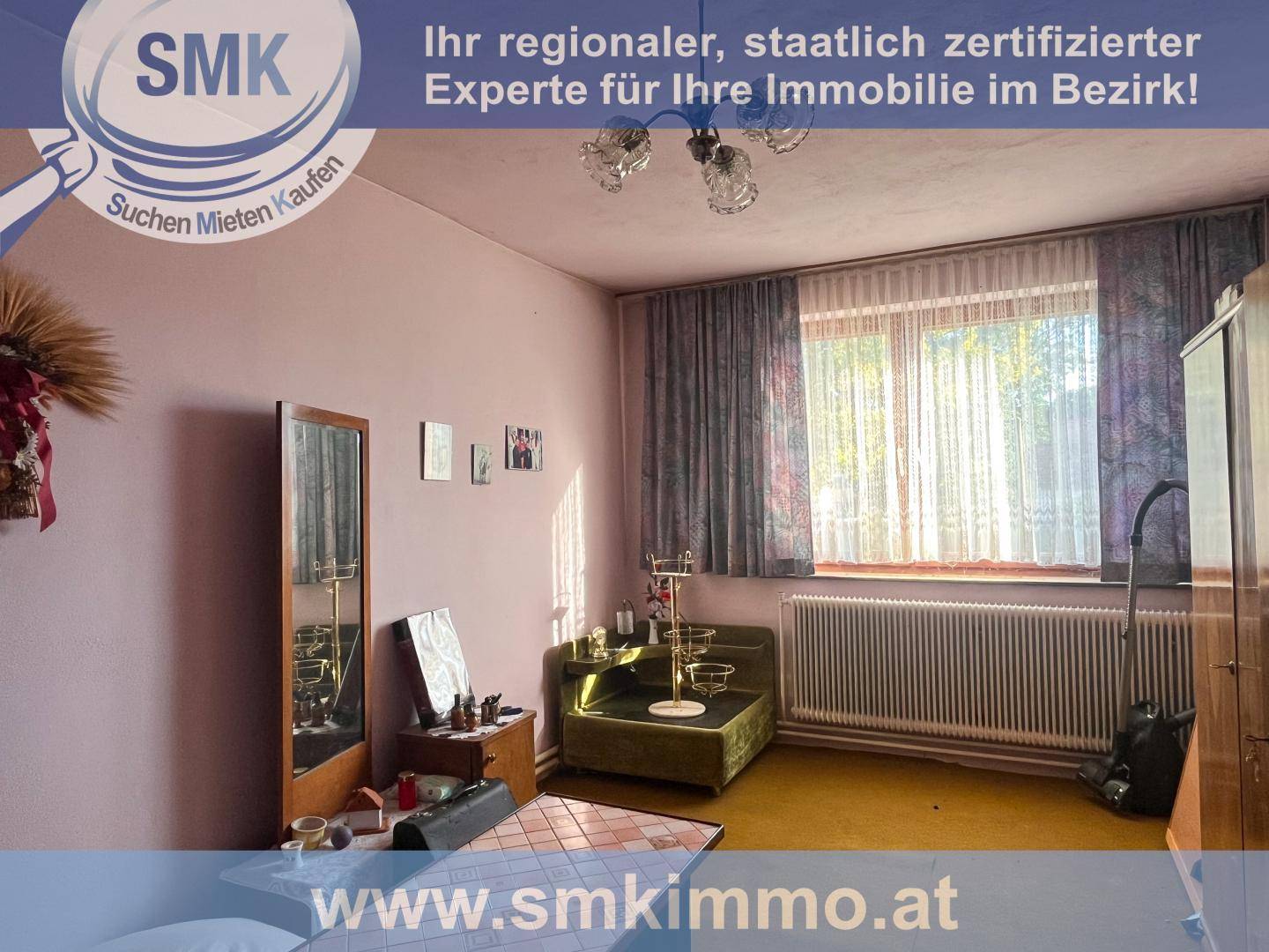 Schlafzimmer mit rosa Wänden, älteren Möbeln und einem großen Fenster mit Vorhängen.