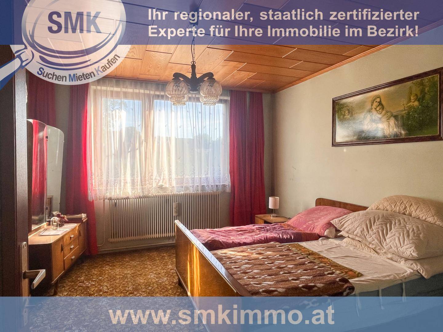 Schlafzimmer mit Doppelbett, Holzdecke und einem großen Fenster, das viel Licht hereinlässt.