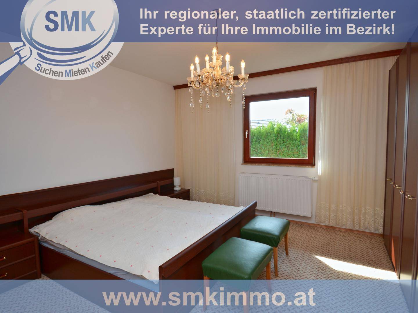 Schlafzimmer mit Doppelbett, Kleiderschränken, Kronleuchter und Blick ins Grüne.