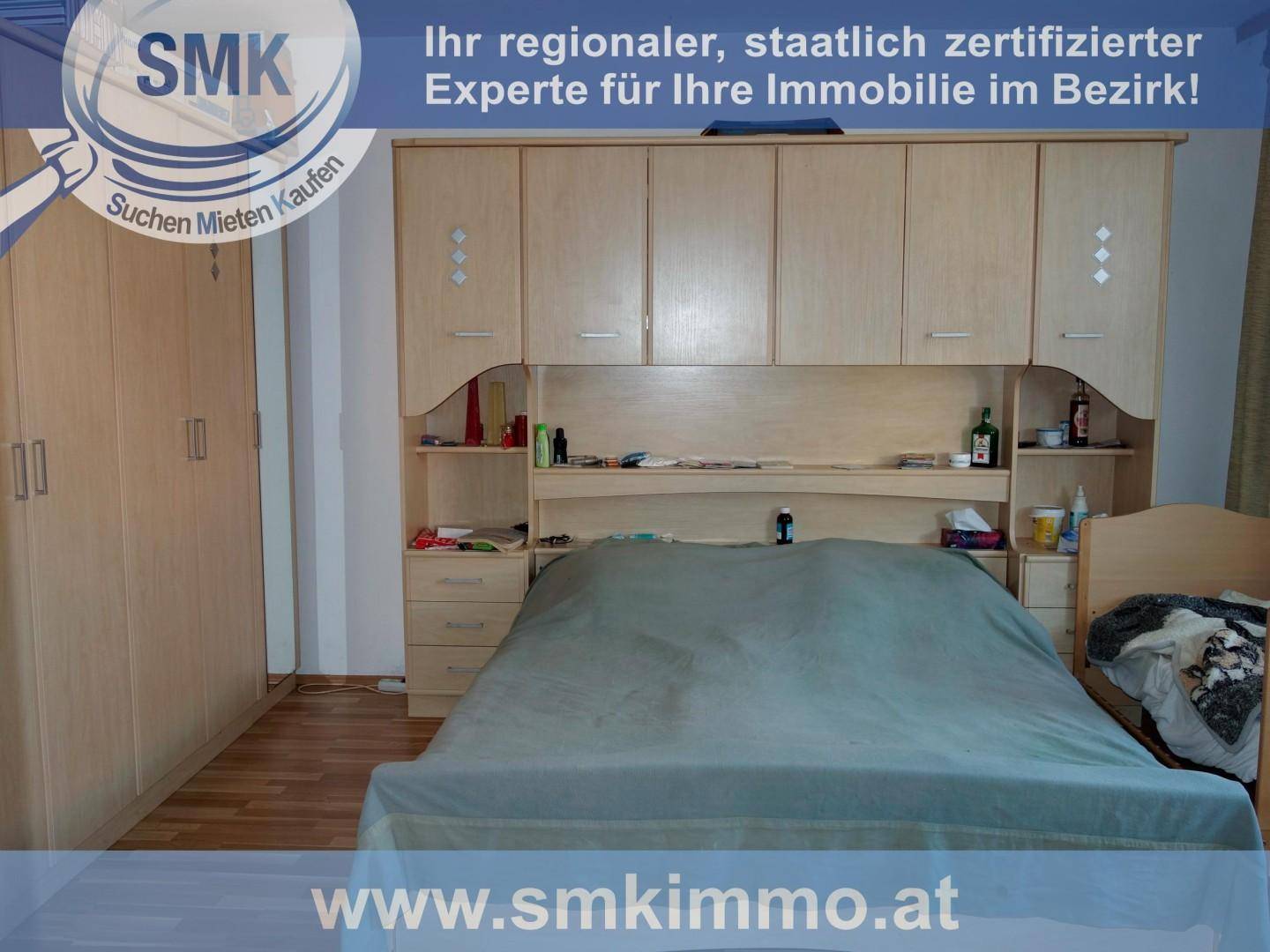 Schlafzimmer mit großem Bett und integrierten Holzschränken über und um das Bett herum.
