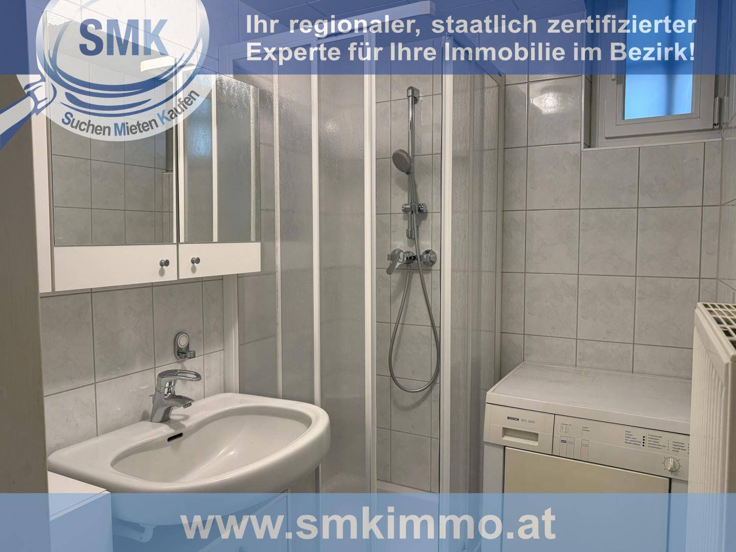 Badezimmer mit Duschkabine, Waschbecken, Spiegelschrank und Waschmaschine, hell gefliest.