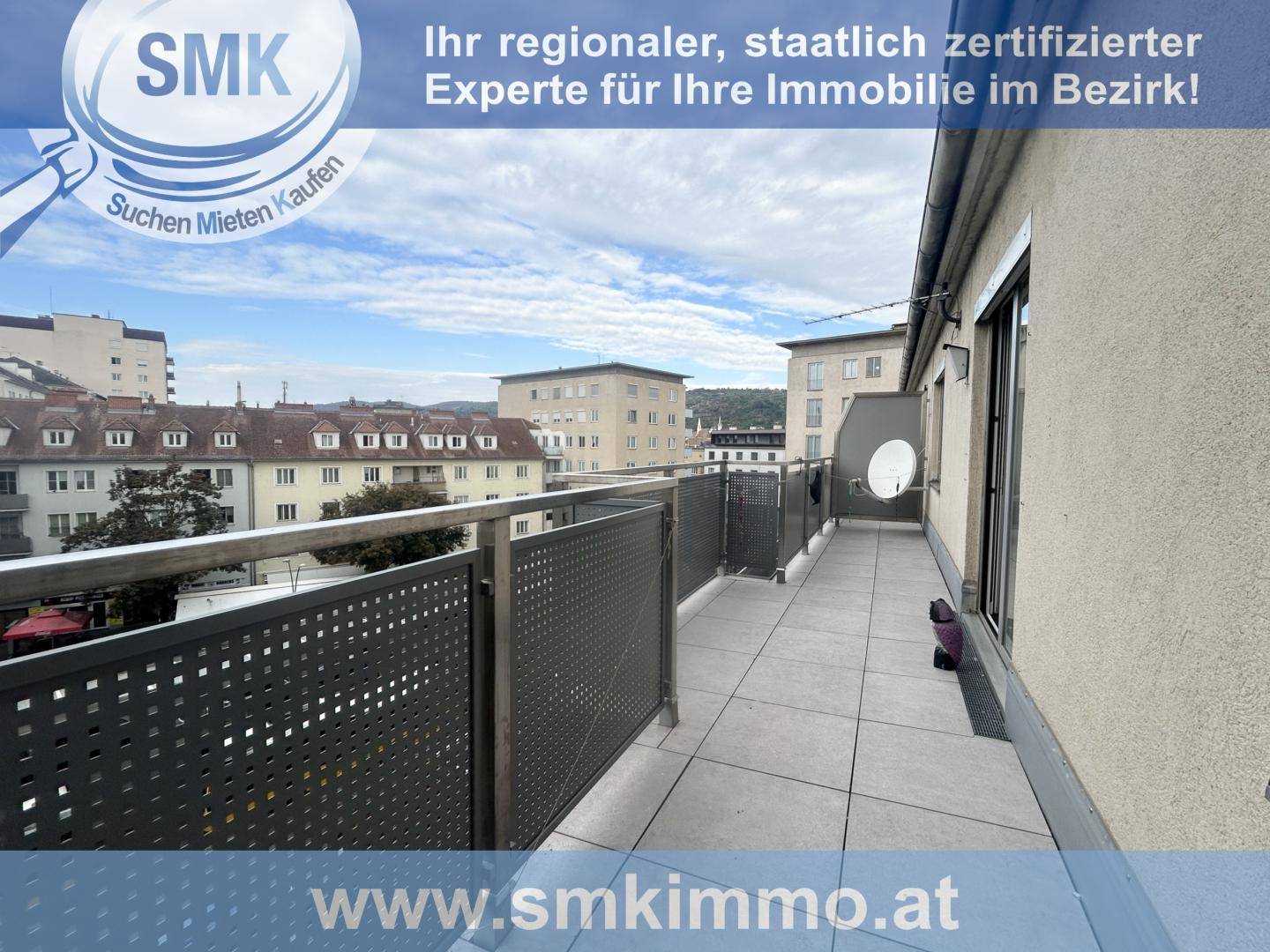 Langer Balkon mit Fliesenboden und Metallgeländer, bietet einen weiten Blick über die Stadt.