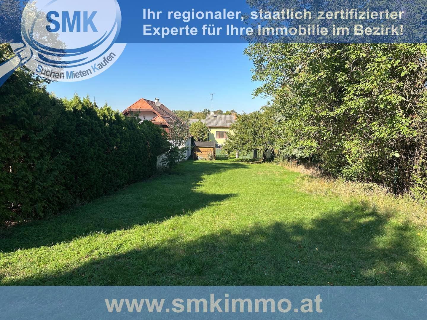 Langer, schmaler Gartenbereich mit Rasen und Hecken, im Hintergrund sind Häuser sichtbar.