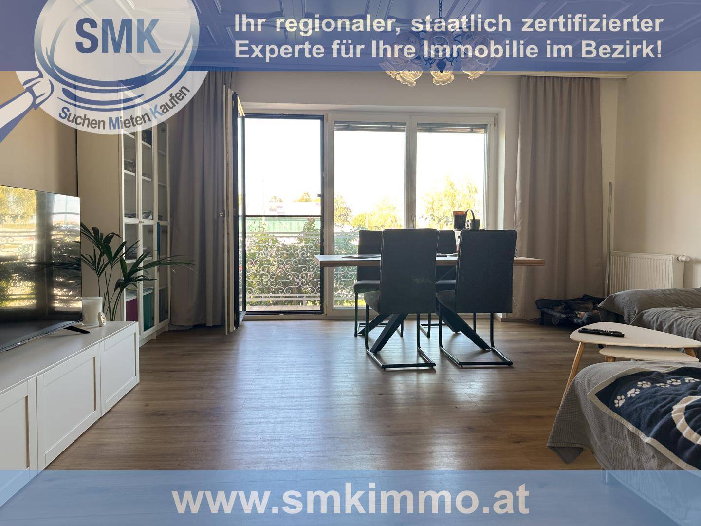 Heller Wohn-Essbereich mit Laminatboden, großem Fenster und Zugang zu einem Außenbereich.