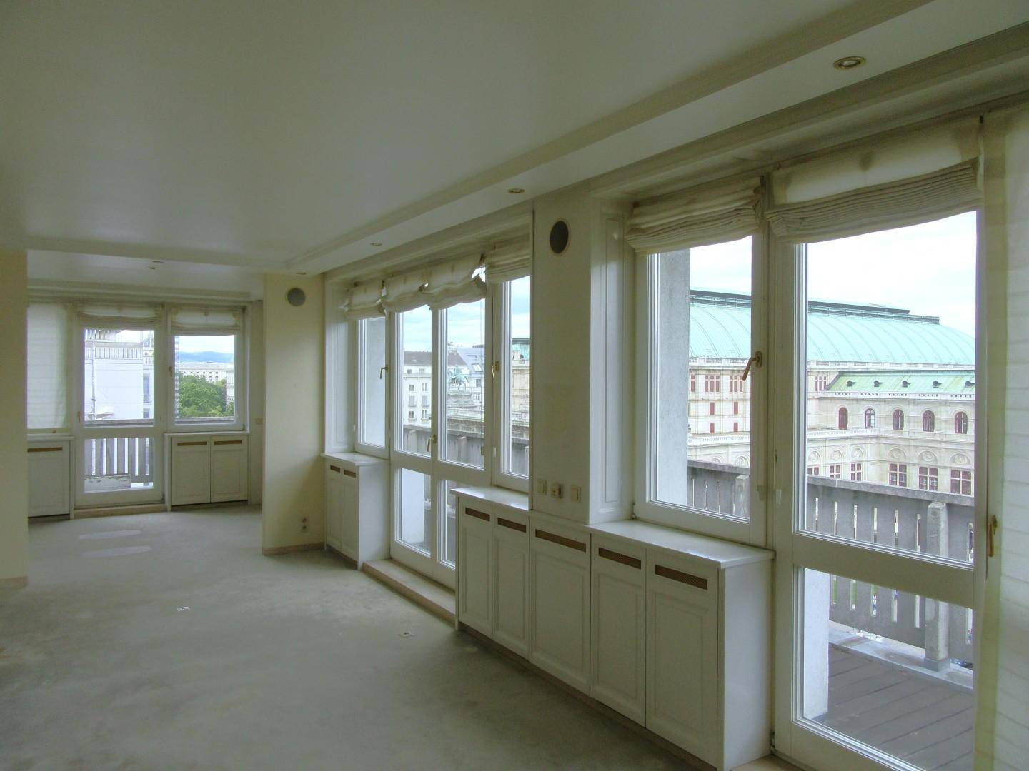 Heller Wohnraum mit großen Fenstern und direktem Blick auf die historische Staatsoper.